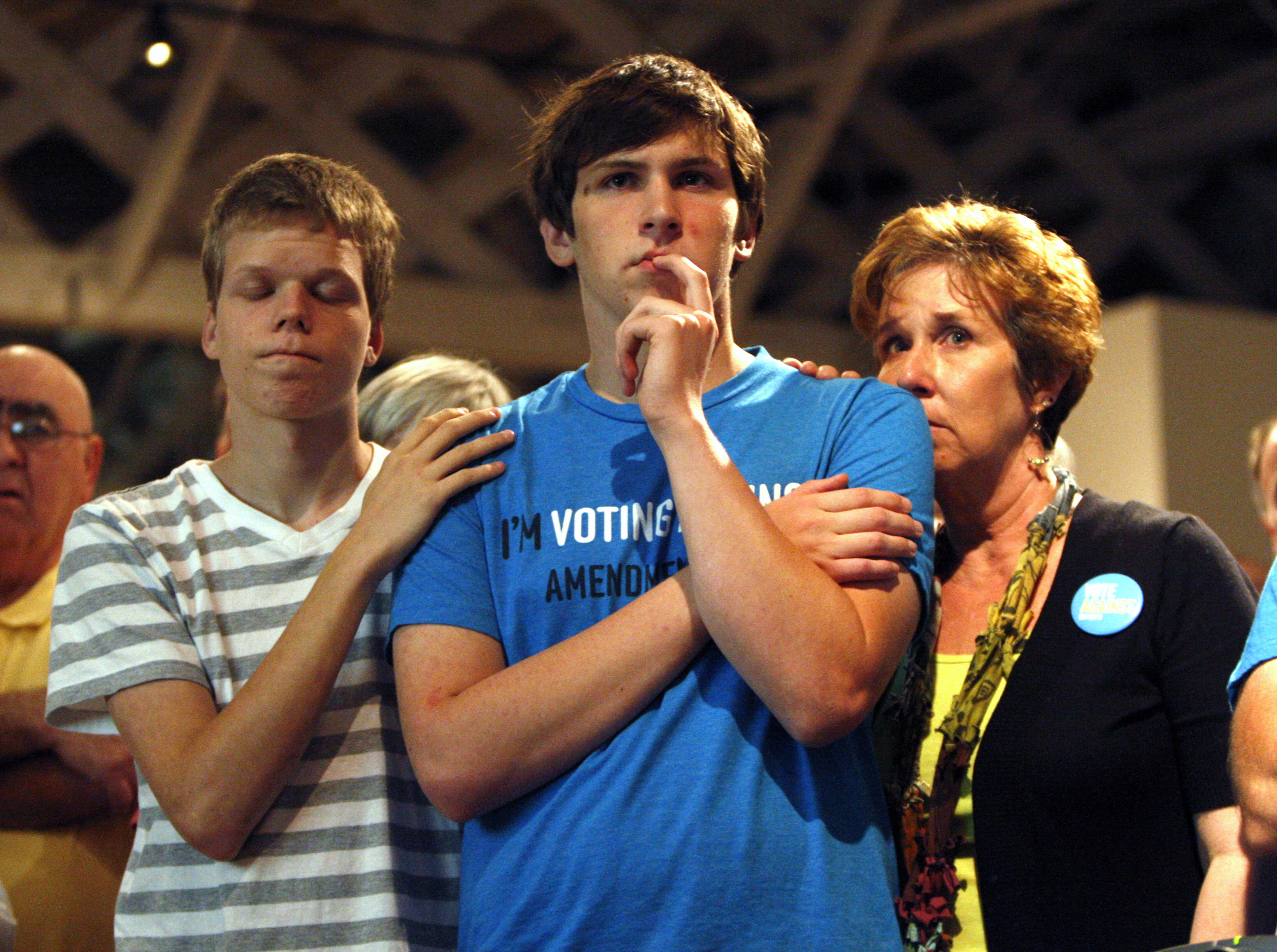 FILE - In this Tuesday, May 8, 2012 file photo, Seth Keel, center, is consoled by his boyfriend, Ian Chambers, left, and his mother Jill Hinton, during a concession speech at an Amendment One opposition party at The Stockroom at 230 in downtown Raleigh, N.C. North Carolina voters approved the constitutional amendment Tuesday defining marriage solely as a union between a man and a woman. But on Friday, June 26, 2015, the U.S. Supreme Court legalized gay marriage nationwide. (Travis Long/The News & Observer via AP) MANDATORY CREDIT: TRAVIS LONG/THE NEWS & OBSERVER (AP)