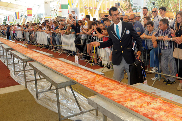 Judge of the Guinness World Records Lorenzo Veltri checks the length of a pizza at the Expo 2015 world's fair in Rho, near Milan, June 20, 2015. (AP/Daniele Mascolo)