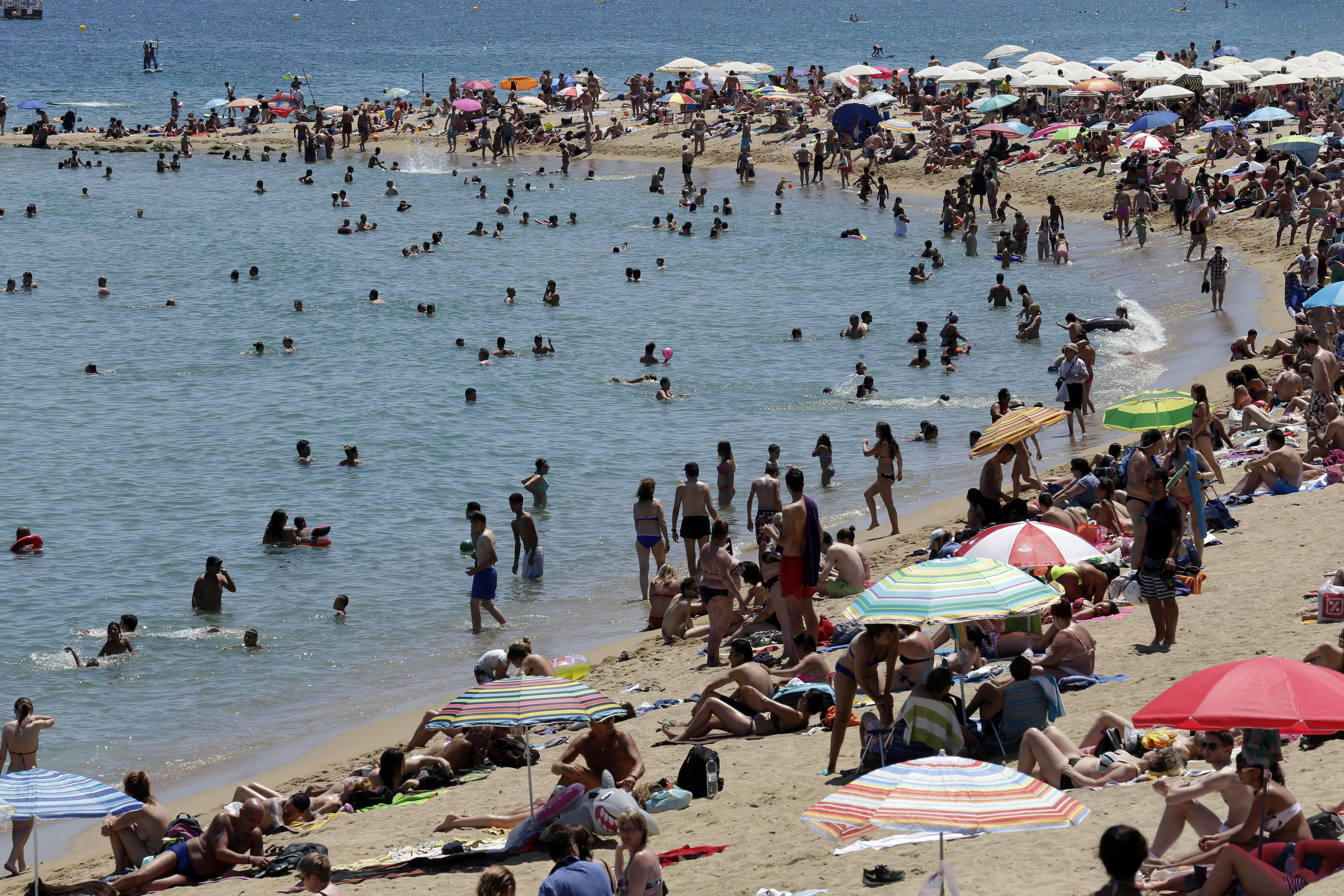 People sunbathe on a beach in Barcelona, Spain, Sunday, June 28, 2015. (AP Photo/Manu Fernandez)