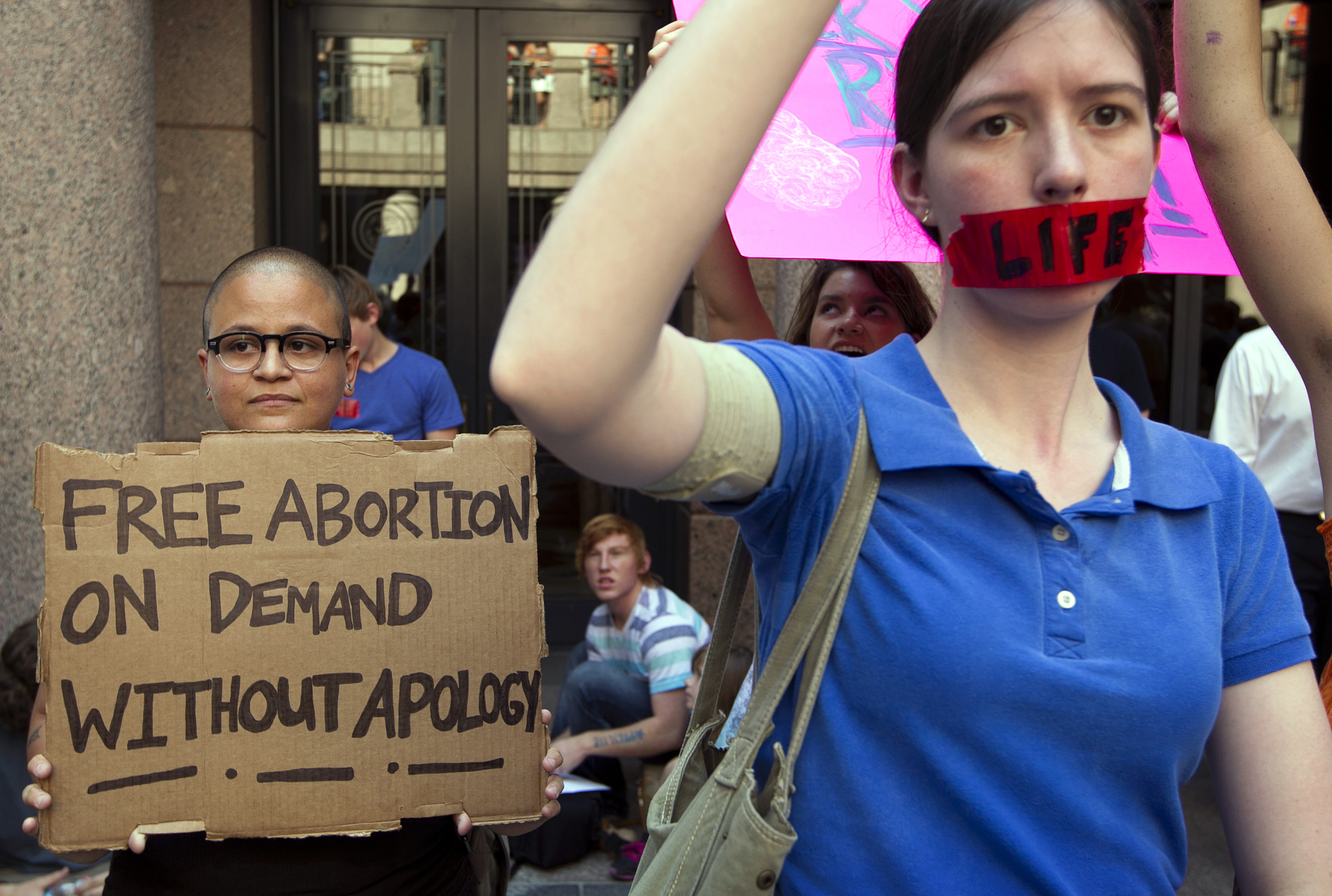 FILE - In a Tuesday July 2, 2013 file photo, pro-abortion rights supporter Yatzel Sabat, left, and anti-abortion protestor Amanda Reed demonstrate at the state Capitol in Austin, Texas. The Supreme Court is considering an emergency appeal from abortion providers in Texas, who want the justices to block two provisions of a state law that already has forced the closure of roughly half the licensed abortion clinics in the state. Ten of the remaining 19 clinics will have to shut their doors by July 1, 2015, without an order from the Supreme Court.  (Jay Janner/Austin American-Statesman via AP, File) (AP/Jay Jenner/Austin American-Statesman)