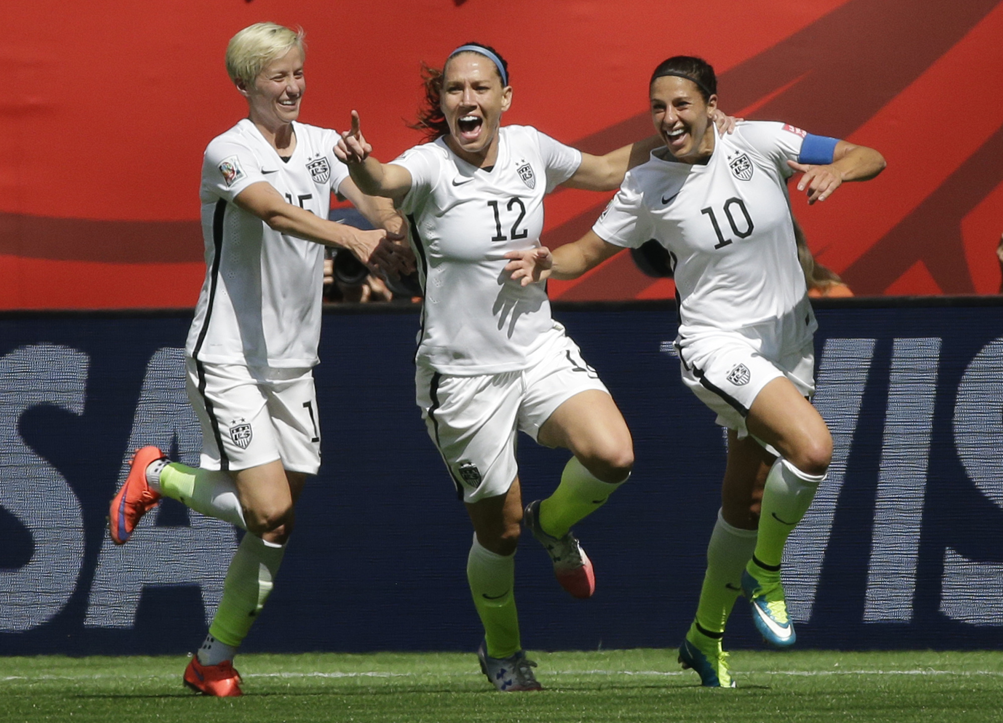 From left, United States' Megan Rapinoe, Lauren Holiday, and Carli Lloyd celebrate after Lloyd scored her second goal of the match against Japan during the first half of the FIFA Women's World Cup soccer championship in Vancouver, British Columbia, Canada, Sunday, July 5, 2015. (AP/Elaine Thompson)