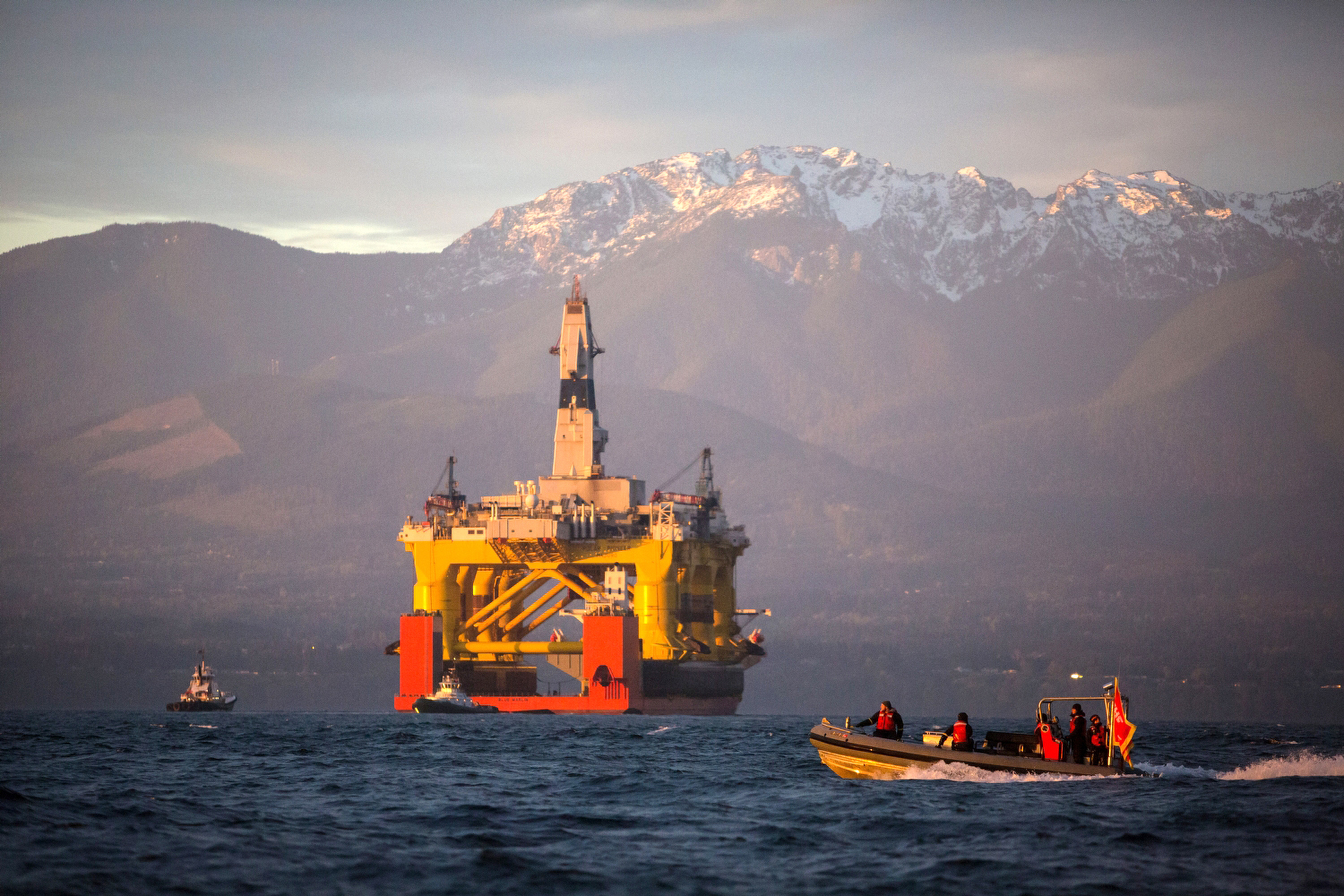 FILE - In this April 17, 2015 file photo, with the Olympic Mountains in the background, a small boat crosses in front of an oil drilling rig as it arrives in Port Angeles, Wash., aboard a transport ship after traveling across the Pacific. (AP)