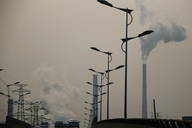 Smoke rises from chimneys of a steel plant next to a viaduct on a hazy day in Tangshan, Hebei province February 18, 2014. (Reuters/Petar Kujundzic)