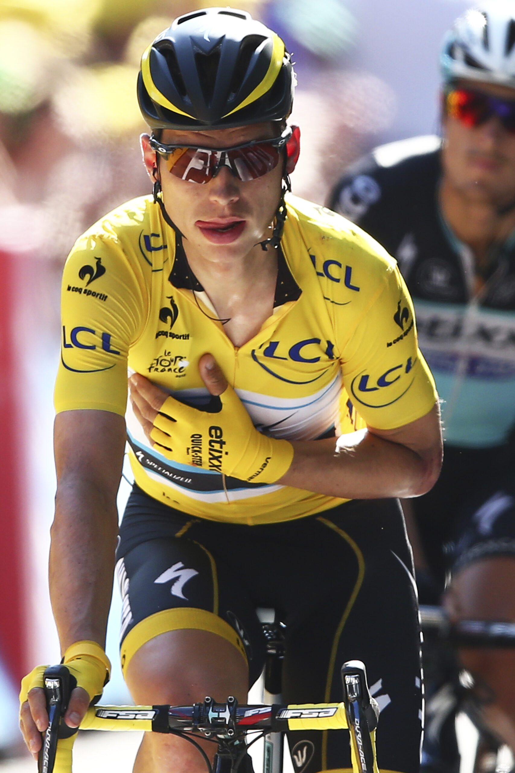 Germany's Tony Martin, wearing the overall leader's yellow jersey, holds his arm in a position which stabilizes his shoulder and collar bone as he crosses the finish line of the sixth stage of the Tour de France cycling race over 191.5 kilometers (119 miles) with start in Abbeville and finish in Le Havre, France, Thursday, July 9, 2015.(AP Photo/Peter Dejong) (Peter Dejong)