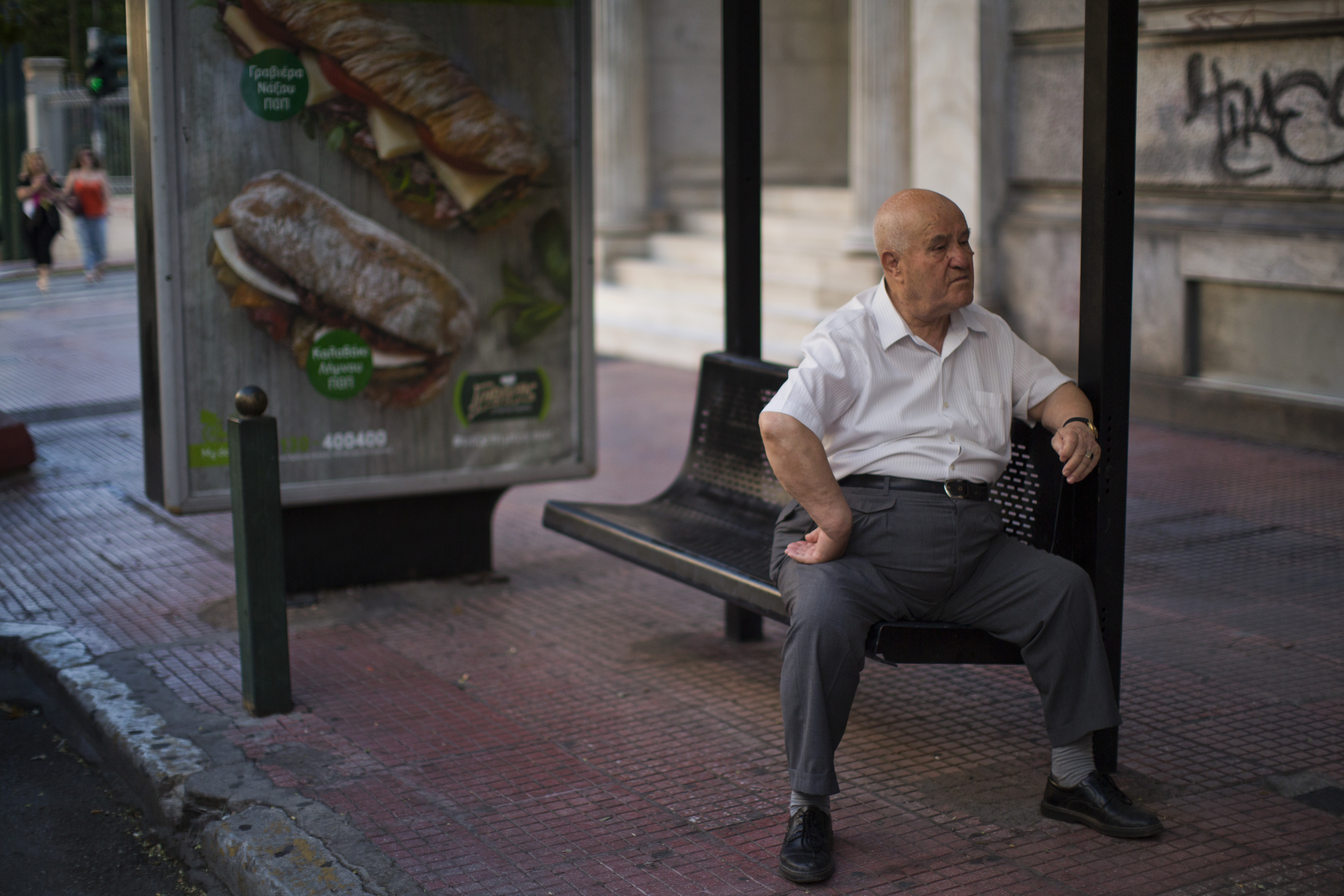 A man waits for public transportation sitting at a bus station in central Athens, Wednesday, July 8, 2015. Frustrated and angry eurozone leaders fearing for the future of their common currency gave the Greek Prime Minister Alexis Tsipras a last-minute chance Tuesday to finally come up with a viable proposal on how to save his country from financial ruin. (AP Photo/Emilio Morenatti) (AP)
