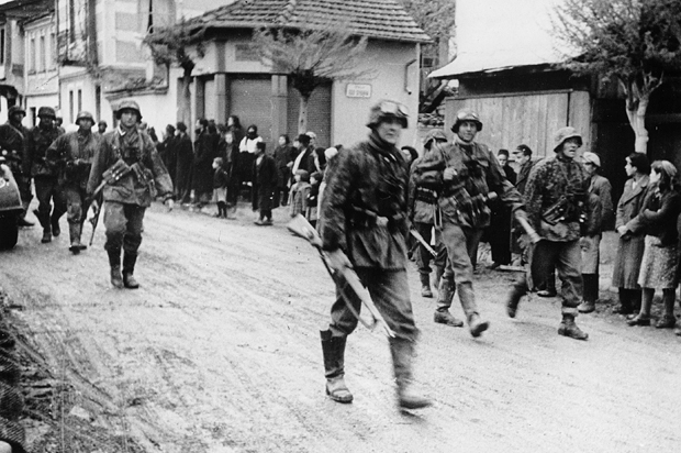Local citizens line the street as they watch the invading German troops move through, at an unknown Greek town, on May 16, 1941. (AP)