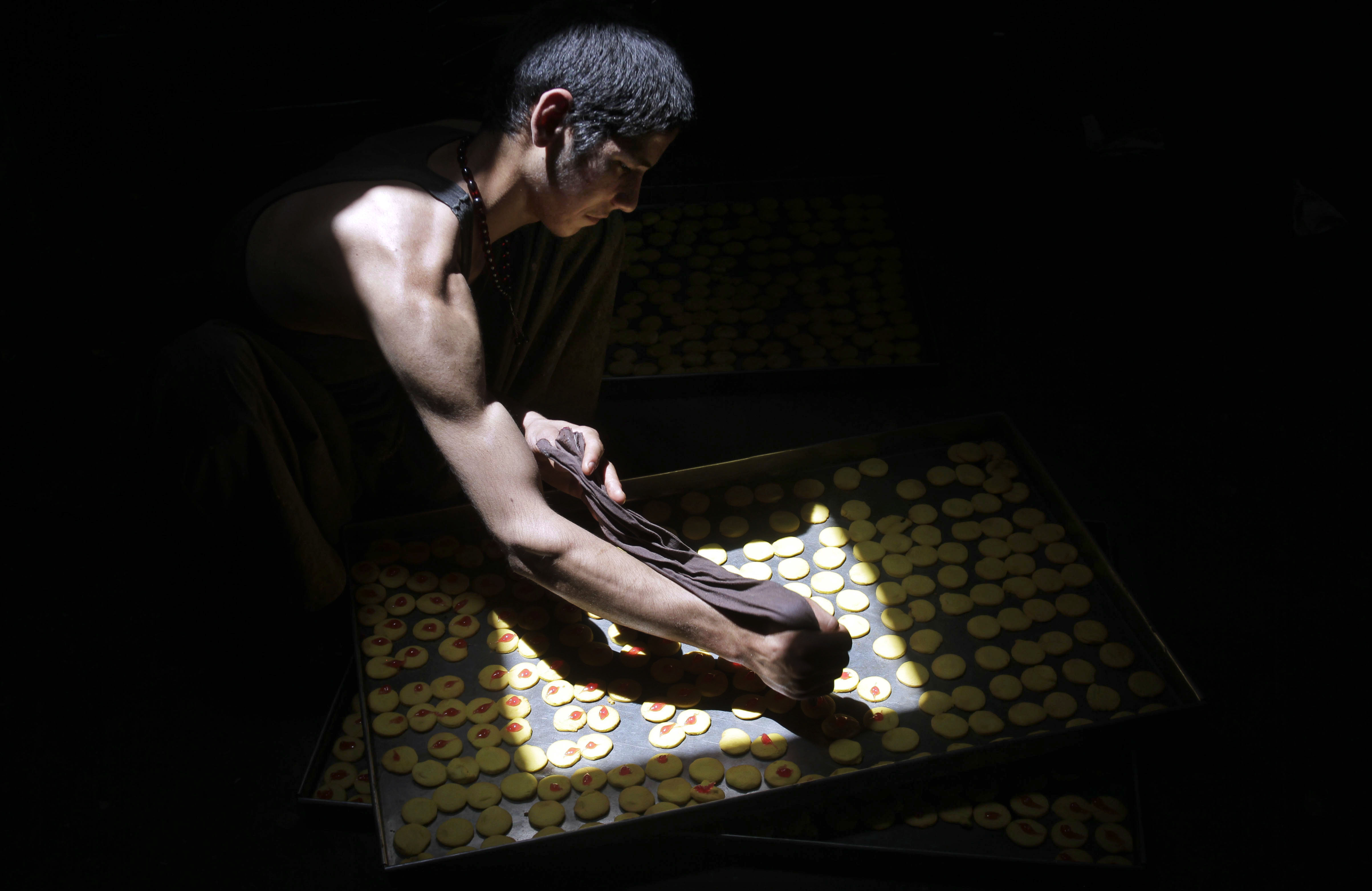 An Afghan vendor prepares sweets to be displayed for sale for the upcoming Eid Al-Fitr celebrations, in Herat, Afghanistan, Wednesday, July 15, 2015. (AP Photo/Hoshang Hashimi) (AP)