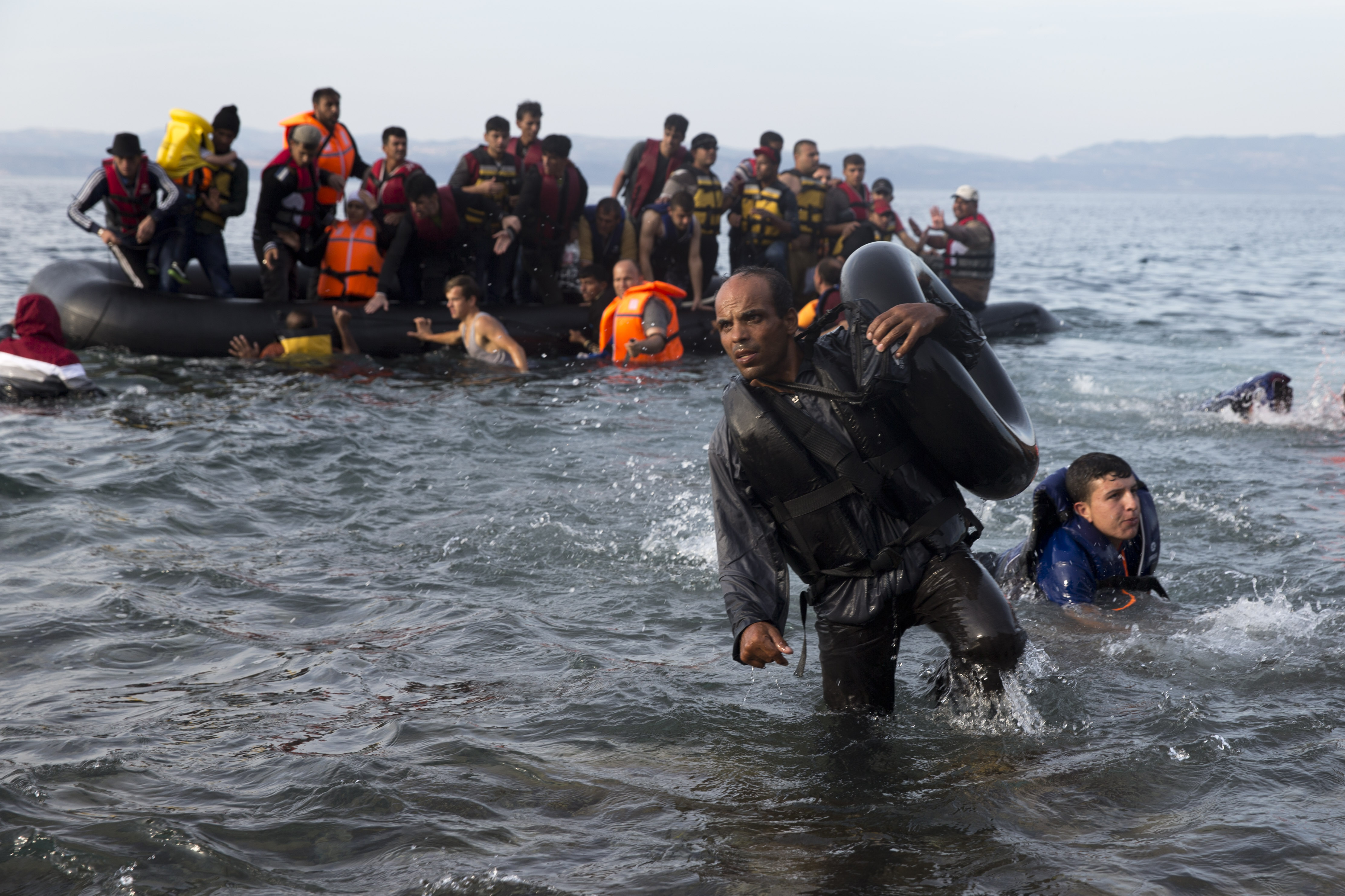 Migrants and refugees arrive on a dinghy after crossing from Turkey to Lesbos island, Greece, Wednesday, Sept. 9, 2015. The head of the European Union's executive says 22 of the member states should be forced to accept another 120,000 people in need of international protection who have come toward the continent at high risk through Greece, Italy and Hungary. (AP Photo/Petros Giannakouris) (AP)
