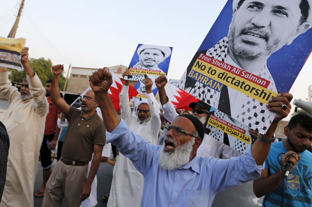 Protesters hold placards with photos of opposition leader and head of Al Wefaq party, Ali Salman, during a protest in the village of Karzakan south of Manama, Bahrain, October 3, 2015. (Reuters/Hamad I Mohammed)