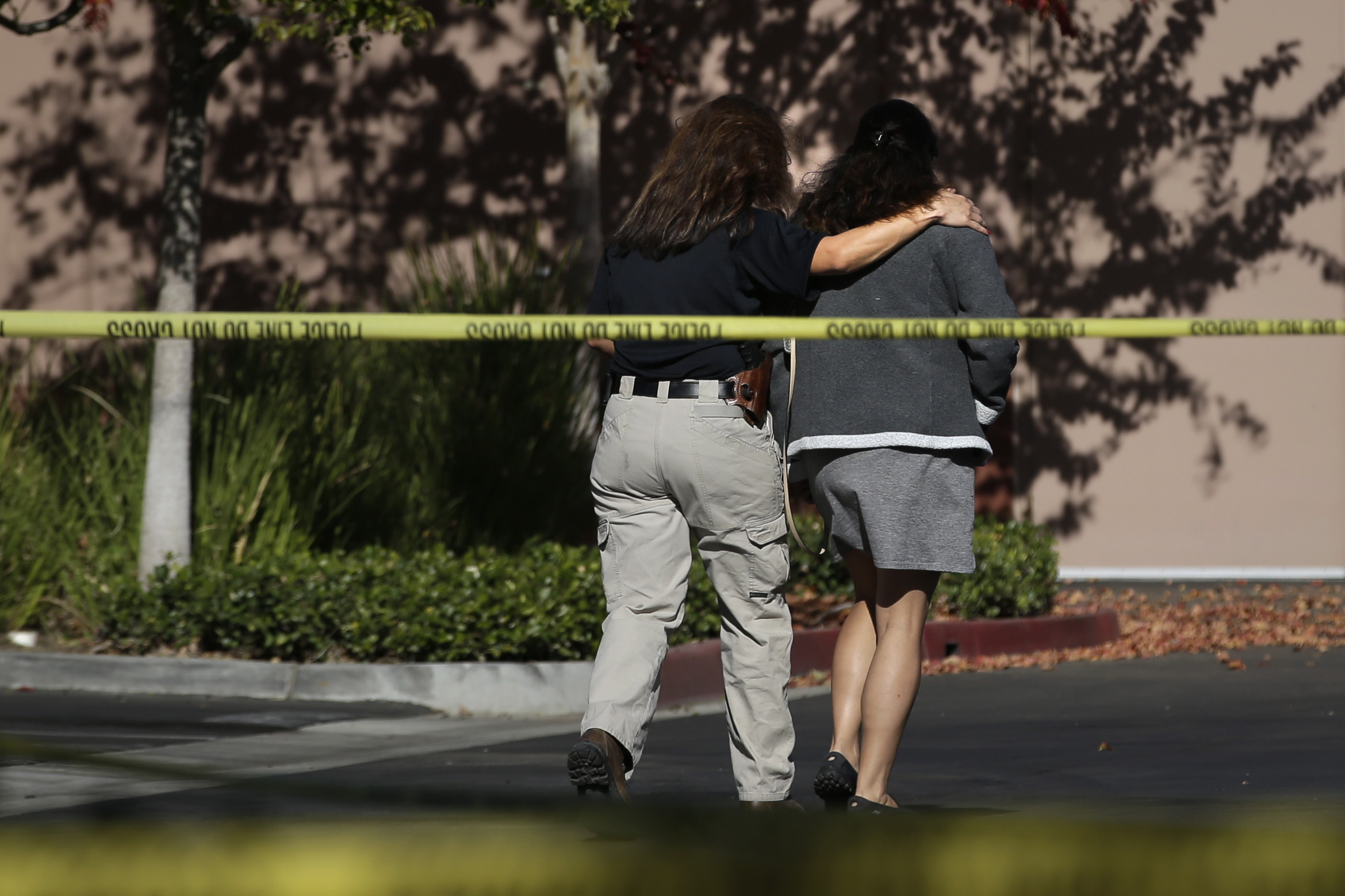 An unidentified woman, right, is comforted by an investigator at the Inland Regional Center, the site of  shooting rampage that killed 14 people, Tuesday, Dec. 8, 2015, in San Bernardino, Calif. ((AP Photo/Jae C. Hong))