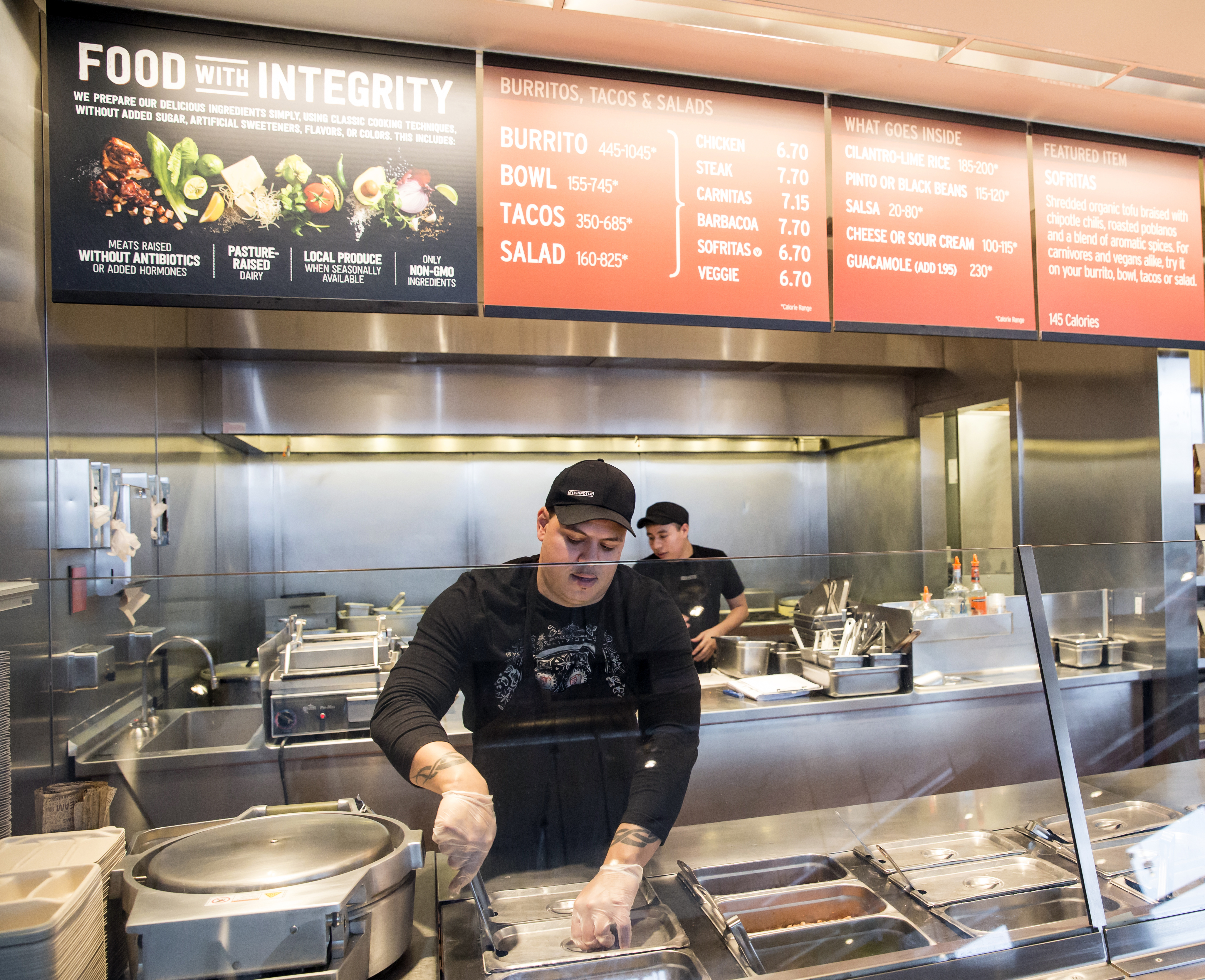 FILE - In this Dec. 15, 2015, file photo, a Chipotle Mexican Grill employee prepares food, in Seattle. After an E. coli outbreak that sickened more than 50 people, Chipotle is changing its cooking methods to prevent the nightmare situation from happening again. (AP Photo/Stephen Brashear, File) (AP)