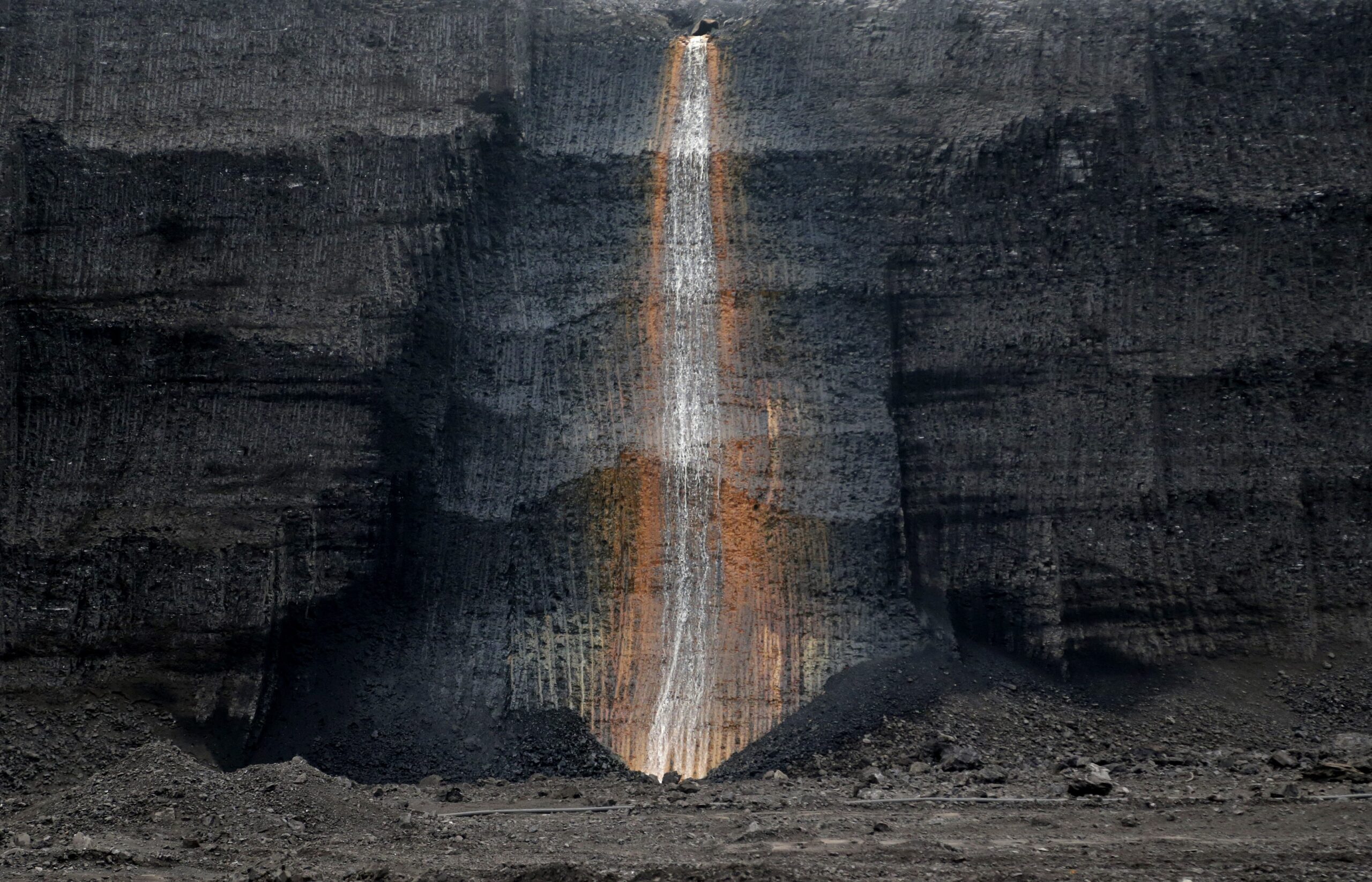 In this picture taken on Thursday, Nov. 12, 2015 near the town of Most, Czech Republic, water runs down inside a giant open pit lignite mine. Ahead of the U.N. climate conference in Paris, the Czech government approved a plan to expand the mining of lignite, a fossil fuel known as brown coal, a major source of greenhouse gases. (AP Photo/Petr David Josek) (AP)