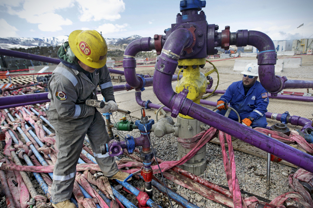 Workers tend to a well head during a hydraulic fracturing operation outside Rifle, in western Colorado, March 29, 2013. (AP/Brennan Linsley)
