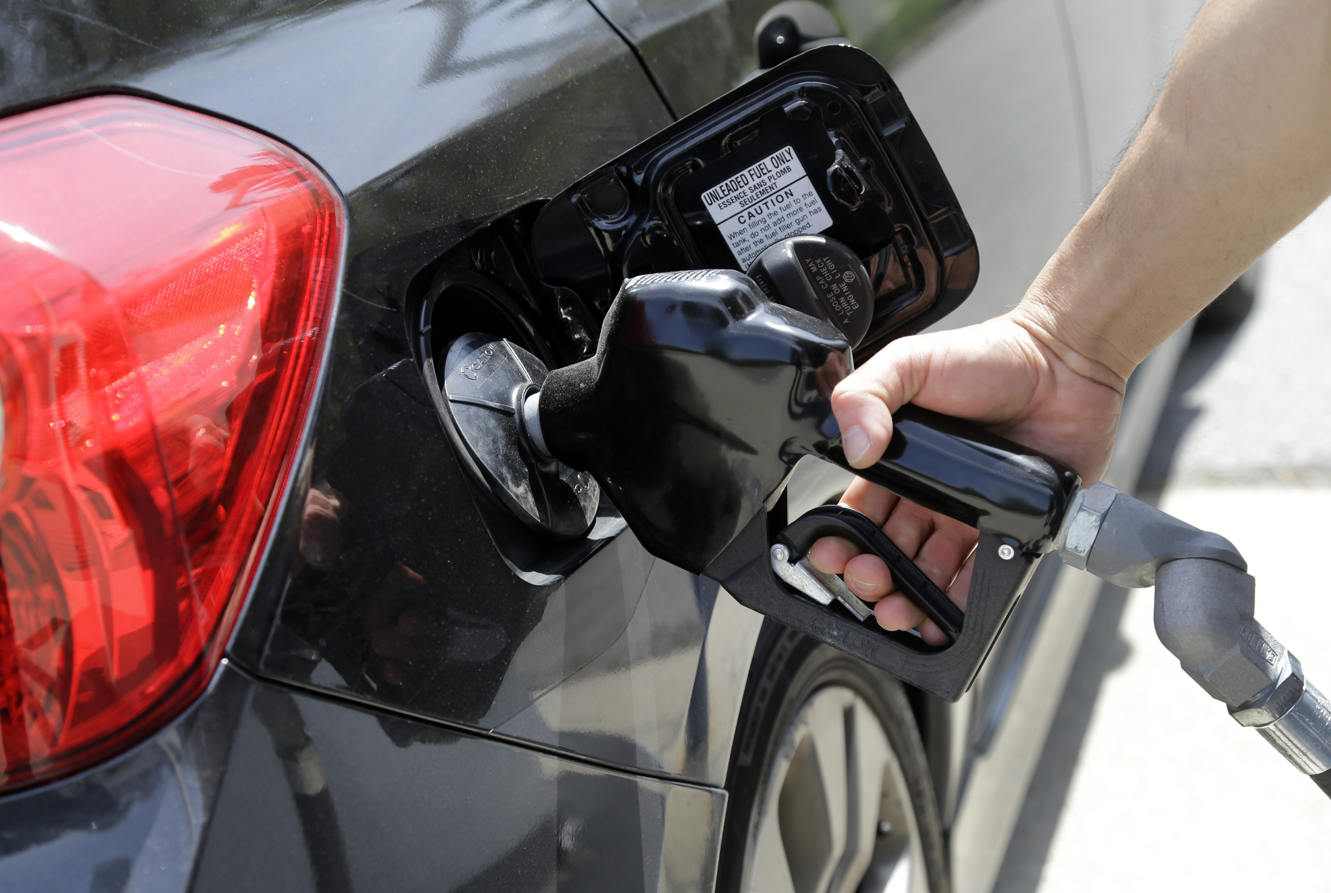 FILE - In this May 8, 2015 file photo, gas station attendant Carlos Macar pumps gas in Andover, Mass.  Gasoline is close to breaking below a key psychological barrier as drivers enjoy some of the cheapest pump prices since the recession. The nationwide average price of a gallon of regular Saturday, Dec. 12, 2015 was $2.02, down 58 cents from this time last year, according to auto club AAA. Experts say it could drop below $2 in the coming days. (AP Photo/Elise Amendola, File) (AP)