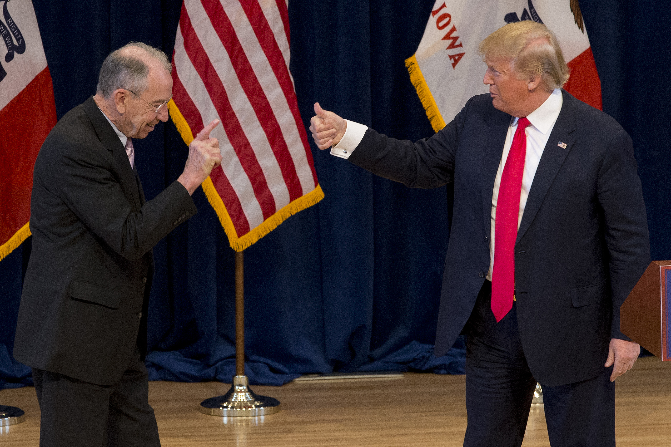 Republican presidential candidate Donald Trump, right, greets Sen. Chuck Grassley, R-Iowa, on stage during a campaign event (AP)