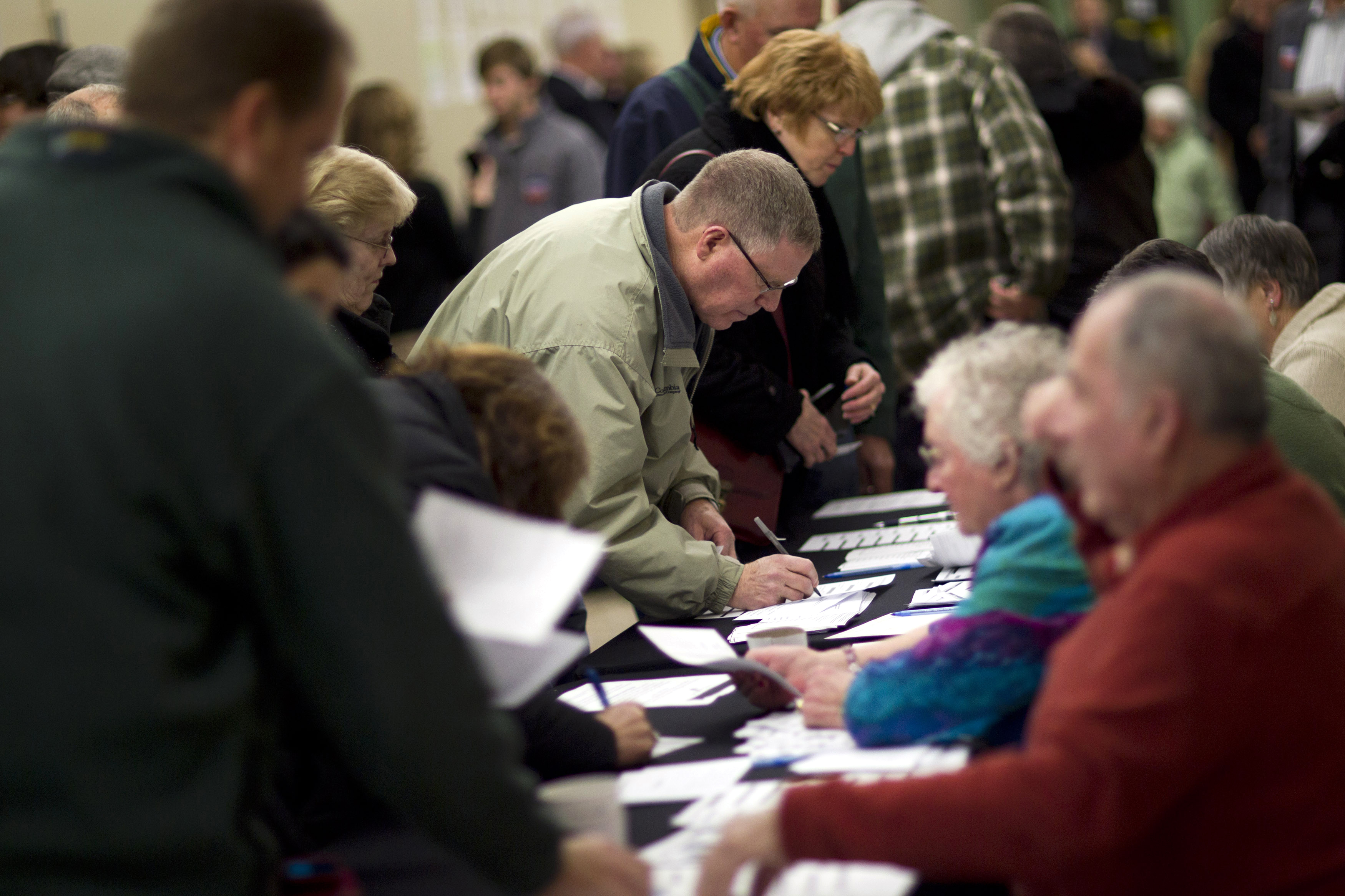 FILE - In this Jan. 3, 2012 file photo, voters sign in on caucus night at Point of Grace Church in Waukee, Iowa. More than 40 years ago, a scheduling quirk vaulted Iowa to the front of the presidential nominating process, and ever since most White House hopefuls have devoted enormous time and money to a state that otherwise would get little attention.  (AP Photo/Evan Vucci, File) (AP)