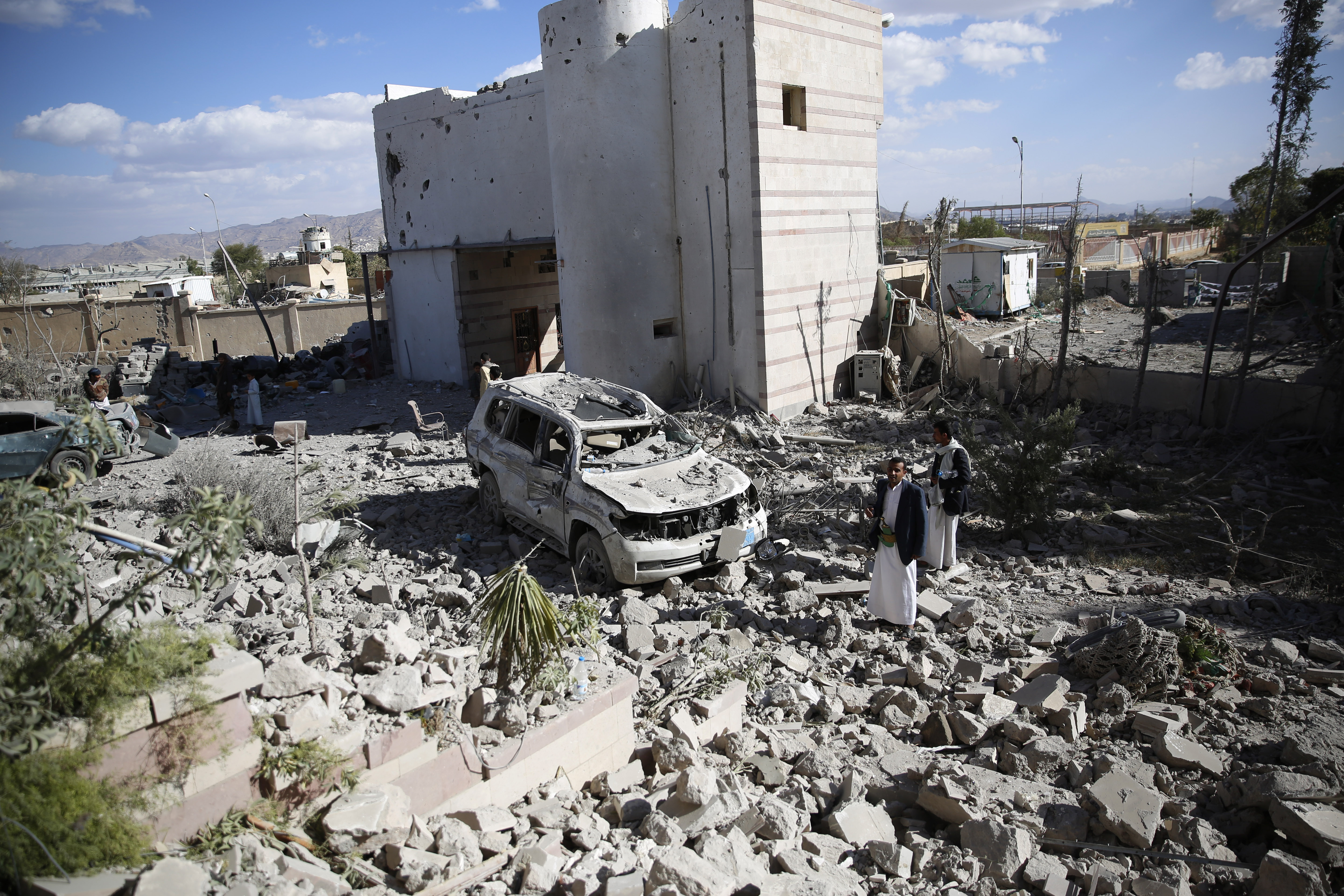 Men gather at the site of a house destroyed by Saudi-led airstrikes in Sanaa, Yemen. (AP/Hani Mohammed)