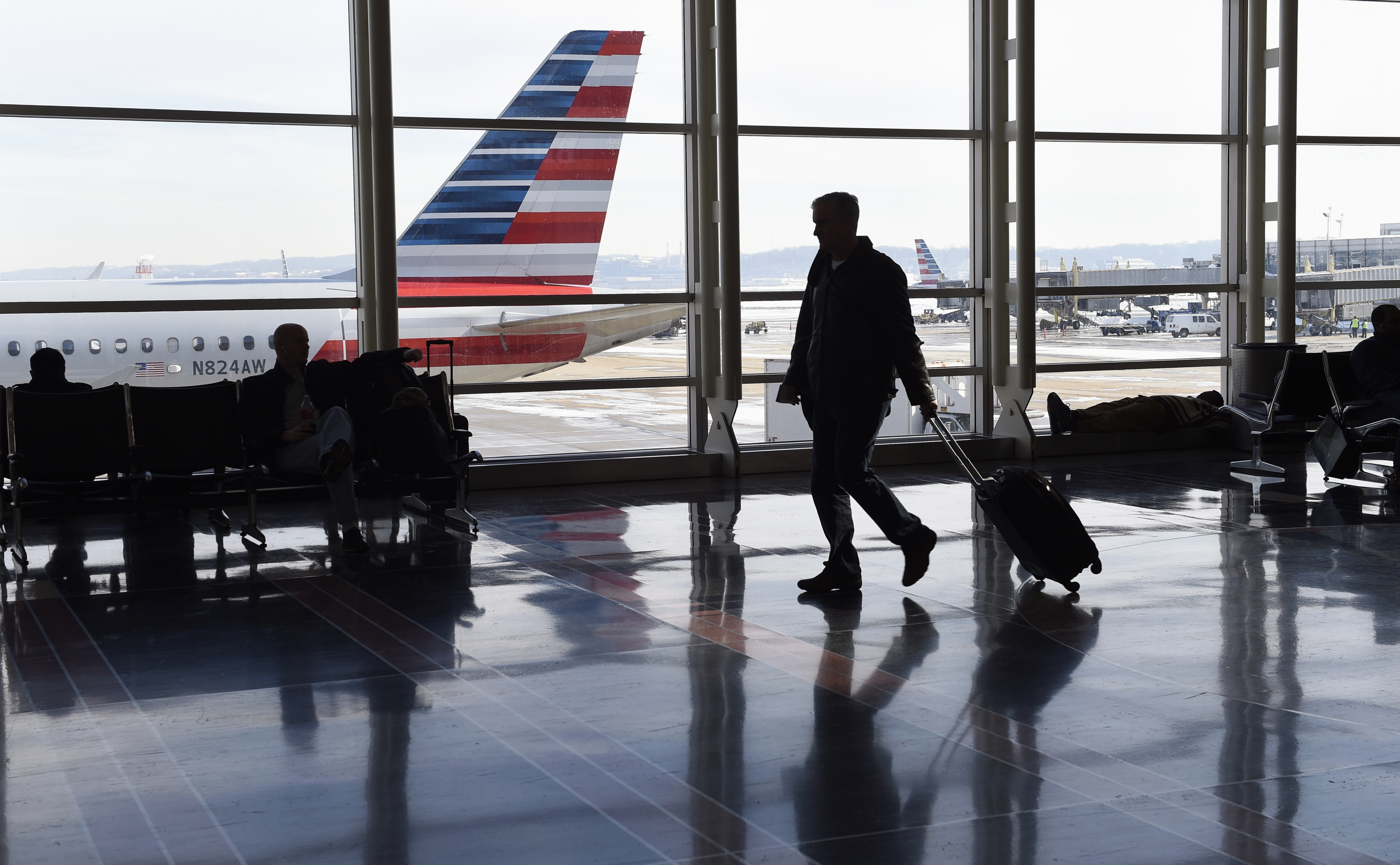 People walk the terminal at Washington's Ronald Reagan National Airport, Monday, Jan. 25, 2016. Flights remained delayed or canceled in the aftermath of a massive weekend blizzard that slammed into the eastern U.S., wreaking havoc on travel in the nations busiest cities, with airports in the New York City and Washington D.C. metro areas were the hardest hit.  (AP Photo/Susan Walsh) (AP)