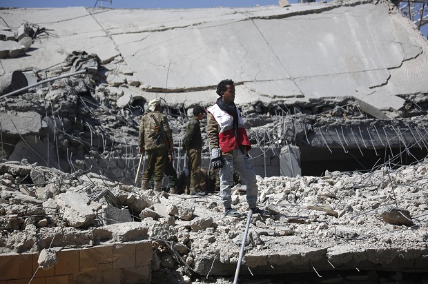 A medic stands on the rubble of the police headquarters after it was destroyed by Saudi-led airstrikes in Sanaa, Yemen, Monday, Jan. 18, 2016. (AP/Hani Mohammed)