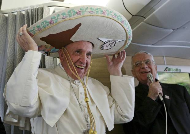 Pope Francis wears a traditional Mexican sombrero hat he received as a gift by a Mexican journalist aboard the plane during the flight from Rome to Habana, Cuba, on his way to a week-long trip to Mexico, Friday, Feb. 12, 2016. The pontiff is scheduled to stop in Cuba for an historical meeting with Russian Orthodox Patriarch Kirill that the Vatican sees as a historic step in the path toward healing the 1,000-year schism that split Christianity. At right is Vatican spokesperson Rev. Federico Lombardi. (Alessandro Di Meo/Pool Photo via AP) (AP)