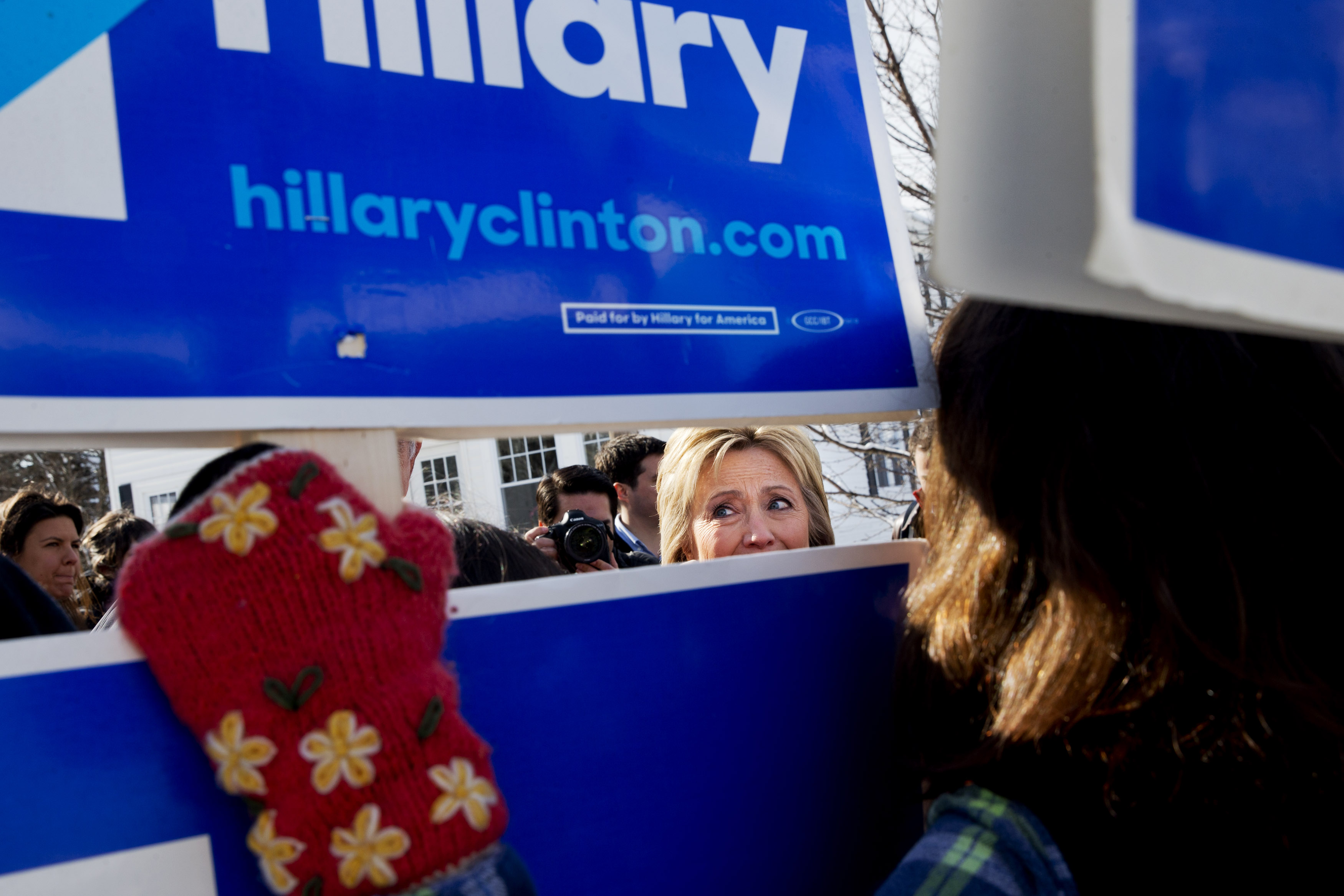 Democratic presidential candidate Hillary Clinton peeks through signs of hers as she greets supporters during a campaign stop in a Manchester, N.H. (AP)