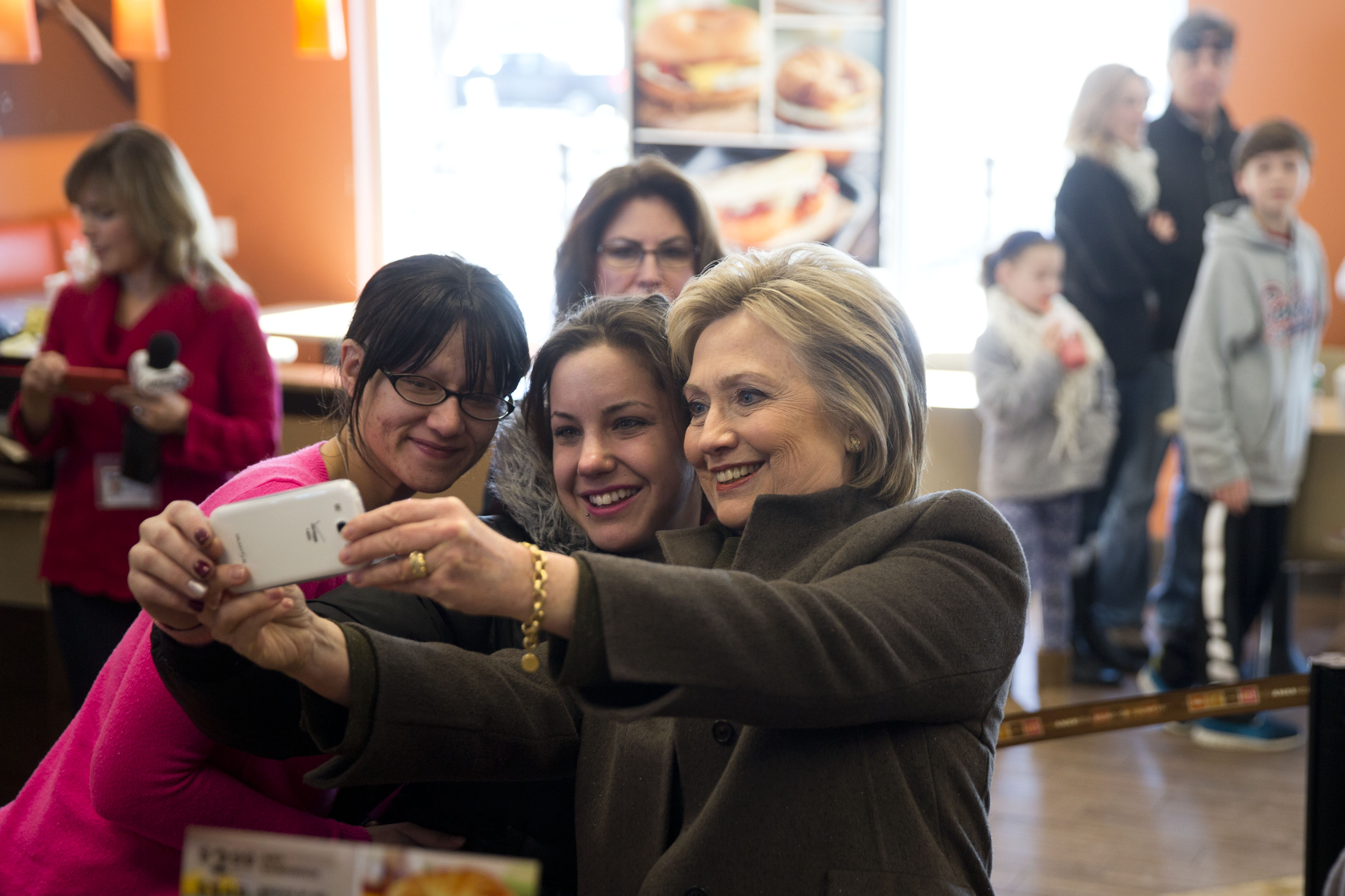 Democratic presidential candidate Hillary Clinton makes a selfie with customers, Sunday, Feb. 7, 2016, at a Dunkin' Donuts in Manchester, N.H. (AP)