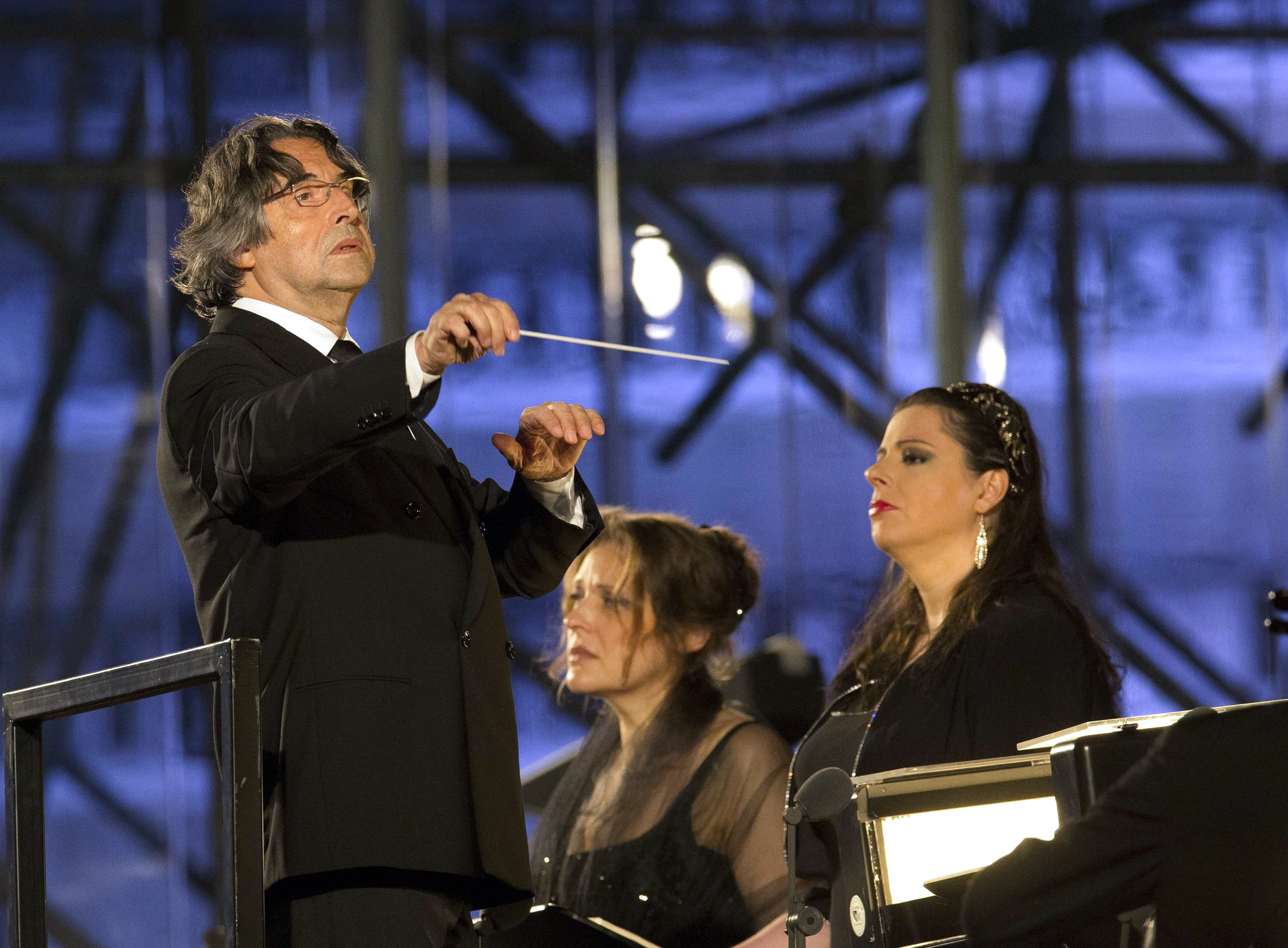 In this photo taken on Sunday, July 6, 2014, Riccardo Muti, left, directs Giuseppe Verdi's Requiem Mass during a concert commemorating the 100th anniversary of the outbreak of World War I, at the Redipuglia War Memorial in Fogliano Redipuglia, Italy. Conductor Riccardo Muti is the musical director of the Chicago Symphony Orchestra. (AP Photo/Paolo Giovannini) (AP)