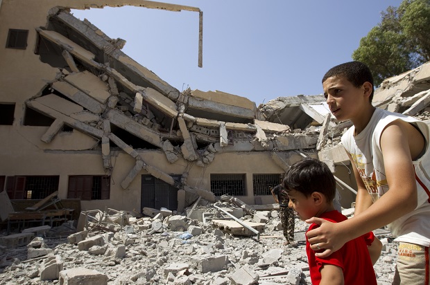 Libyan boys walk near the wreckage of a school bombed by NATO forces in August 2011 (Reuters/Caren Firouz)