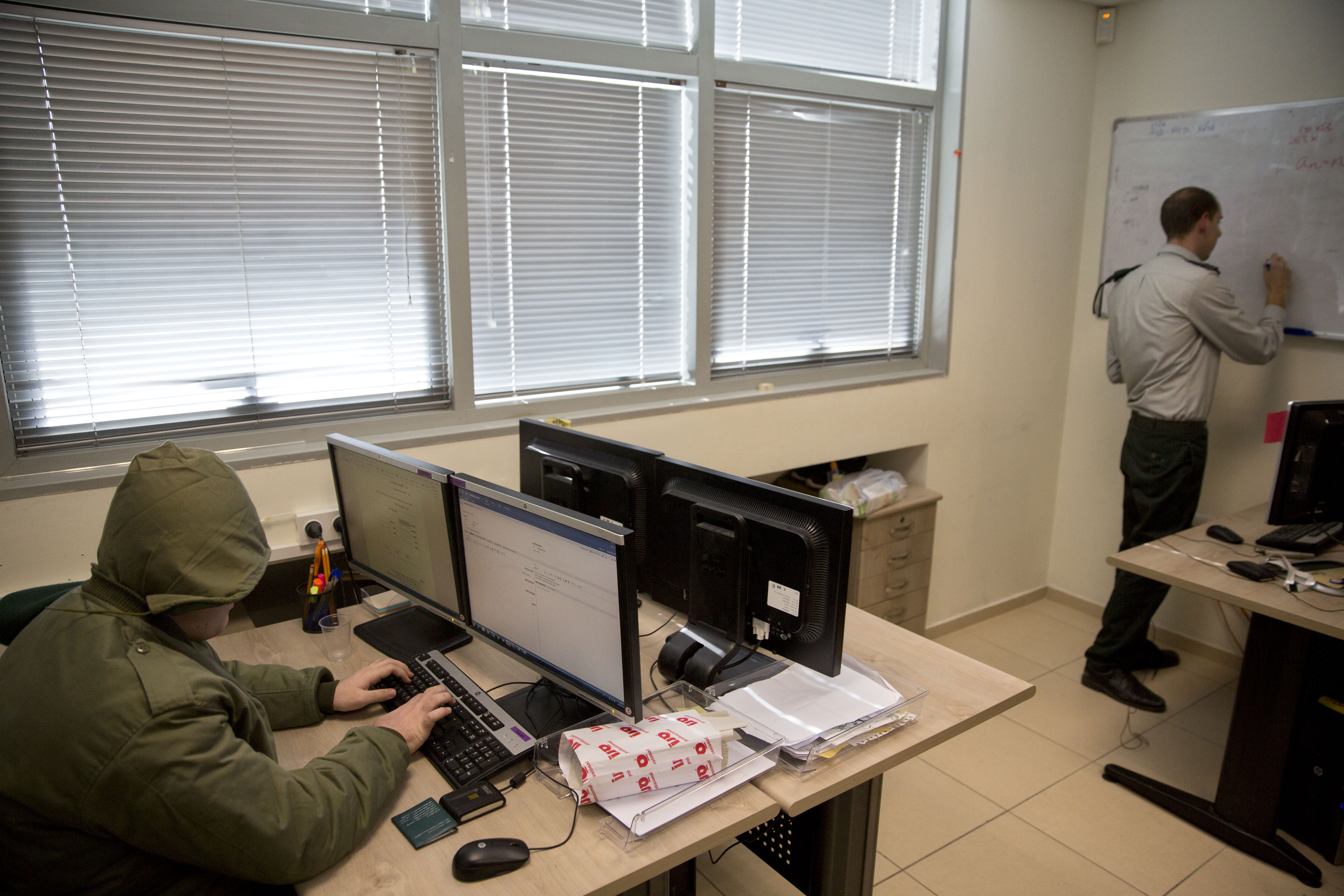 In this photo taken Wednesday, Feb. 9, 2016, an Israeli soldier on the autism spectrum works on a computer as his commander writes on a whiteboard in a small office in downtown Tel Aviv. A military program called seeing into the distance, provides training and assistance to Israelis on the autism spectrm who wish to enlist in the military. (AP Photo/Sebastian Scheiner) (AP Photo/Sebastian Scheiner)