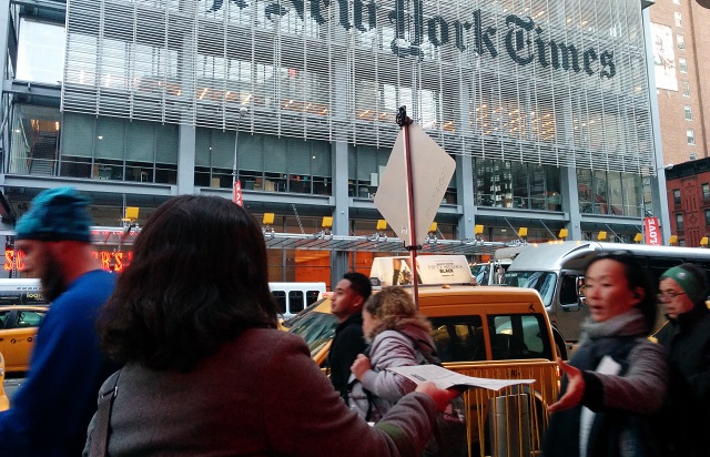 An activist handing out the fake New York Times edition outside of the real newspaper's building (NYT-IP/JVP/Jews Say No!)