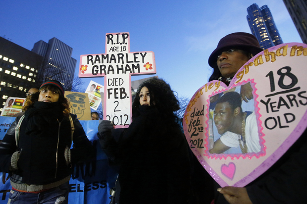 Constance Malcolm, mother of fatal police shooting victim Ramarley Graham, left, stands with protesters in front of the U.S. Attorney's office, Dec. 19, 2014, in New York. (AP/Jason DeCrow)