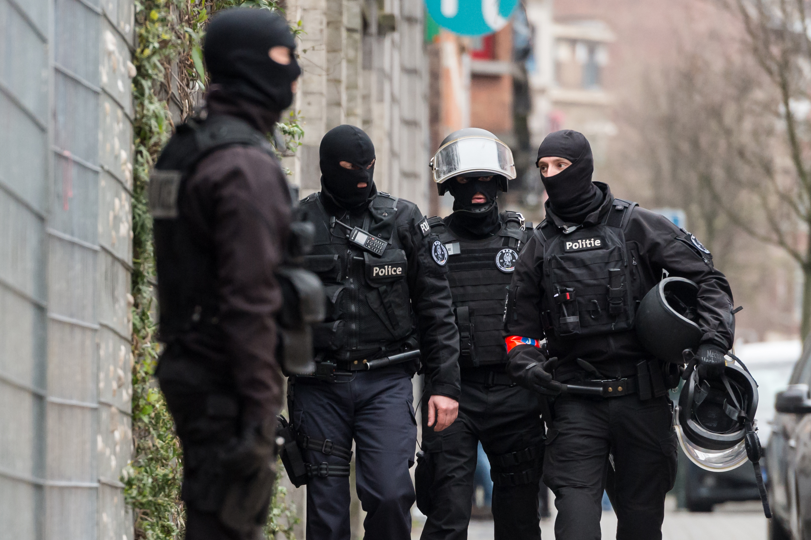 Police officers stand guard during a raid in the Molenbeek neighborhood of Brussels, Belgium, Friday March 18, 2016. (AP Photo/Geert Vanden Wijngaert)