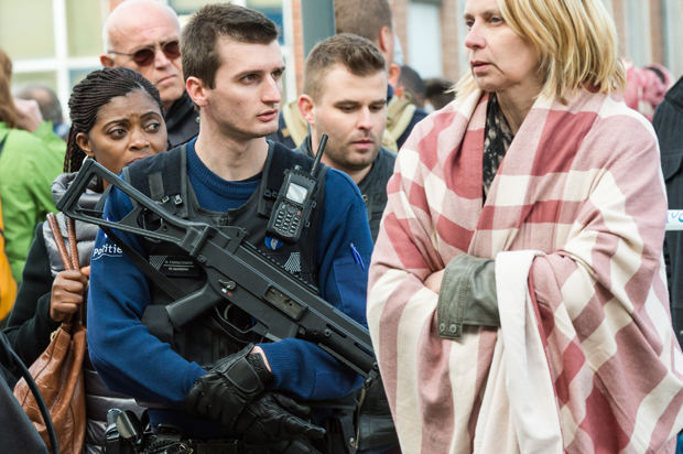 A police officer stands guard as people are evacuated from Brussels airport after explosions, March 22, 2016. (AP/Geert Vanden Wijngaert)