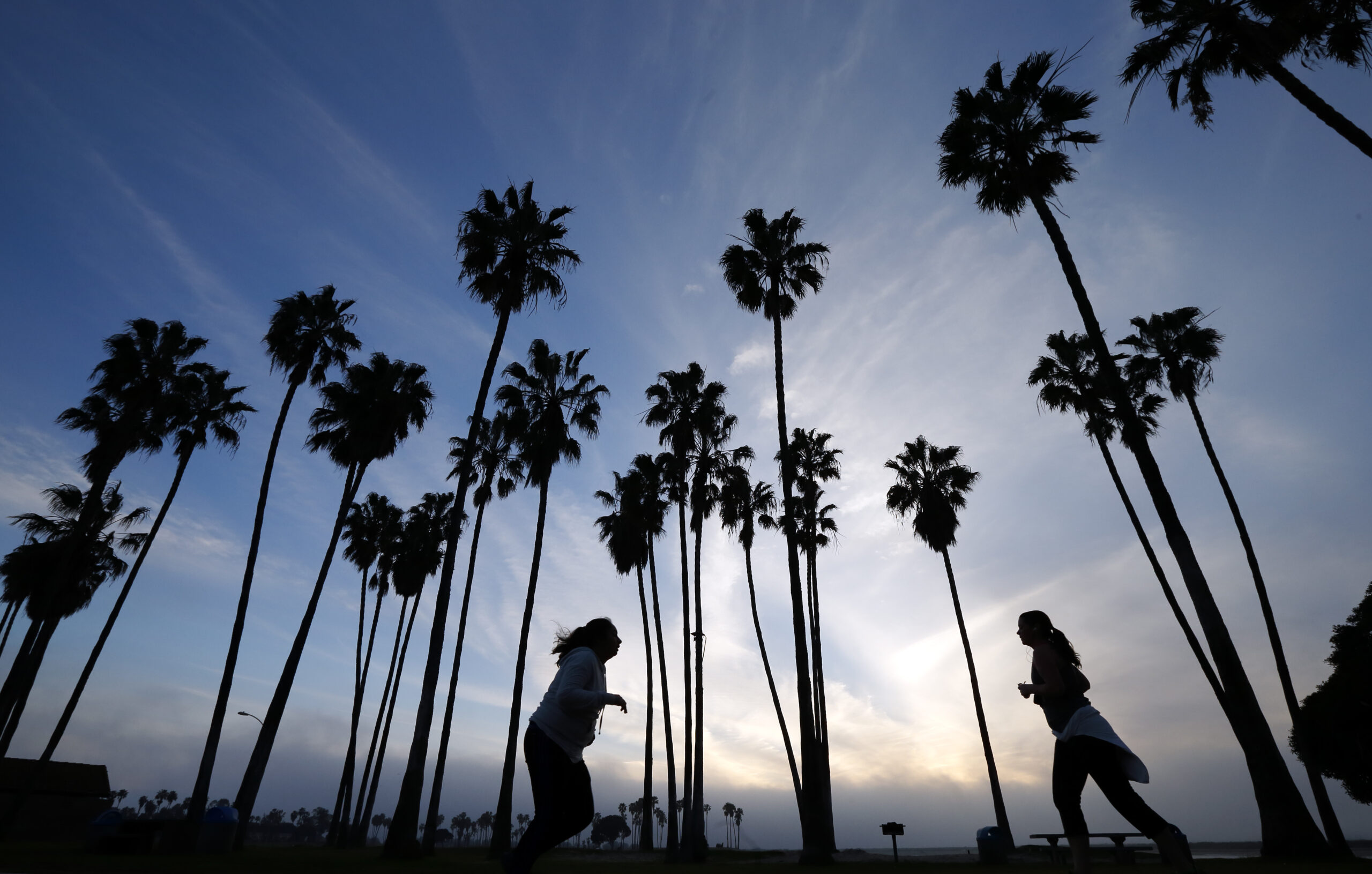FILE - In this Feb. 23, 2016, file photo, women run as the sun sets in San Diego. Winter, especially in the southern half of the state, has been dry, and rain and snowfall in the weeks ahead would have to be extensive to make up lost ground in the state, even with the current forecast of a series of early March storms heading directly toward California. (AP Photo/Gregory Bull, File) (AP)