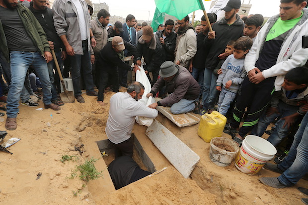 Mourners bury the body of 10-year-old Palestinian boy Yassin Abu Khoussa, who was killed by an Israeli airstrike in northern Gaza on March 12, 2016 (Reuters/Mohammed Salem)