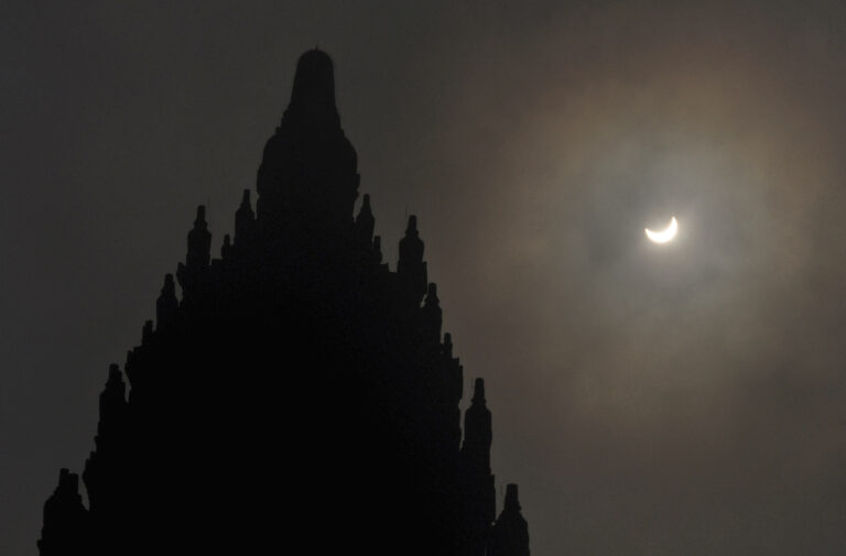 A partial solar eclipse is seen behind the 9th century Prambanan Temple in Yogyakarta, Indonesia, Wednesday, March 9, 2016. The rare astronomical event is being witnessed Wednesday along a narrow path that stretches across 12 provinces encompassing three times zones and about 40 million people. (AP Photo/Slamet Riyadi) (AP)