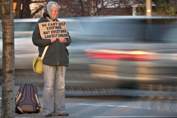FILE - In this Thursday, Nov. 14, 2013 file photo, Susan St. Amour, 54, a homeless woman, panhandles during the evening commute in Portland, Maine.  A federal judge heard testimony Tuesday, Nov. 19, 2013, from the American Civil Liberties Union of Maine challengung an ordinance banning panhandlers from standing in street medians in Portland. (AP Photo/Robert F. Bukaty, File) (AP/Robert F. Bukaty)