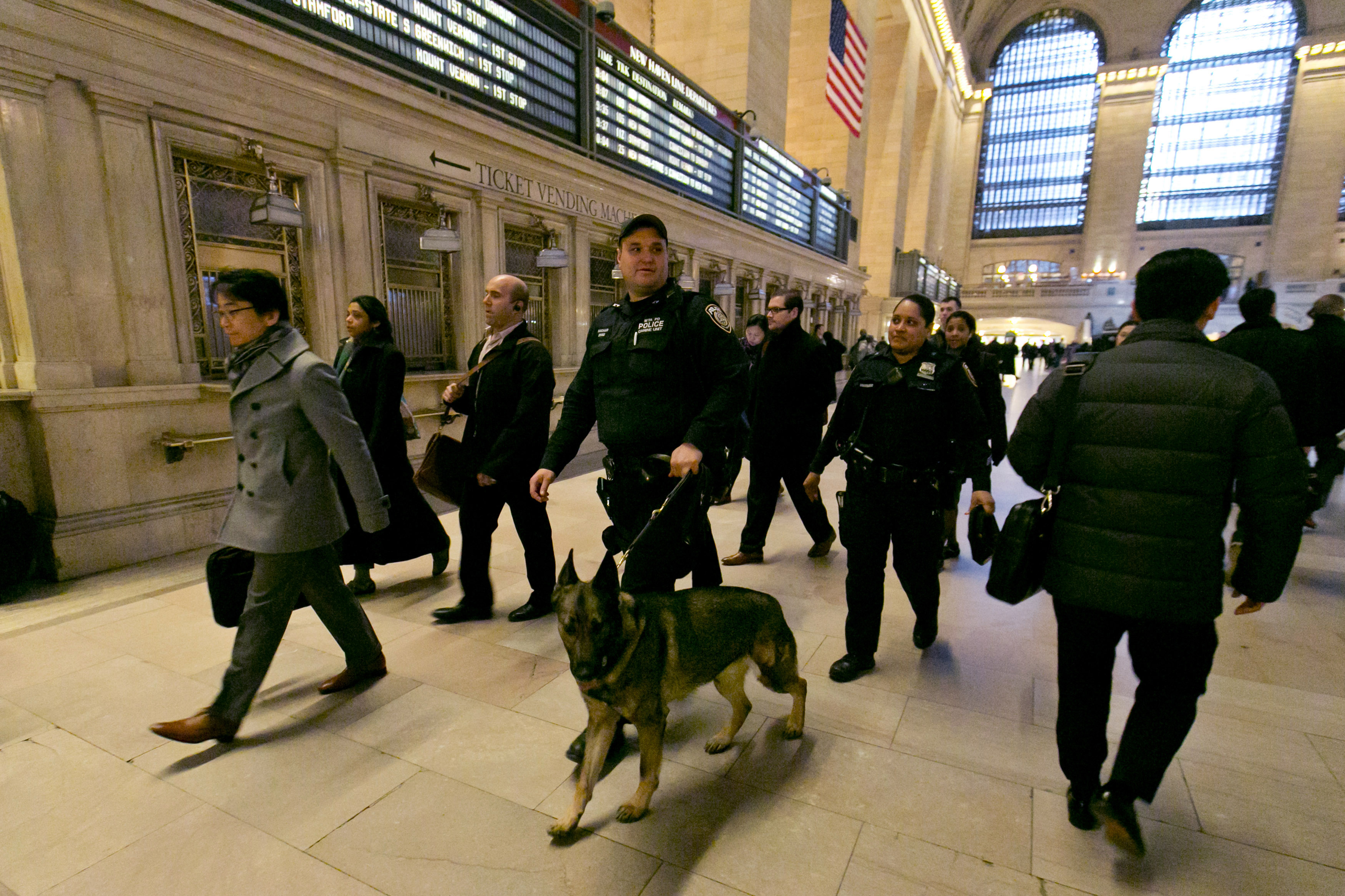 FILE - In this March 22, 2016 file photo, Metro-North Railroad police officers with a police dog patrol Grand Central Terminal, in New York.  The best line of defense against a Brussels-style attack in the nation's largest subway system may be man's best friend. The NYPD this week graduated eight new dogs specifically for its elite counterterrorism unit. (AP Photo/Richard Drew)