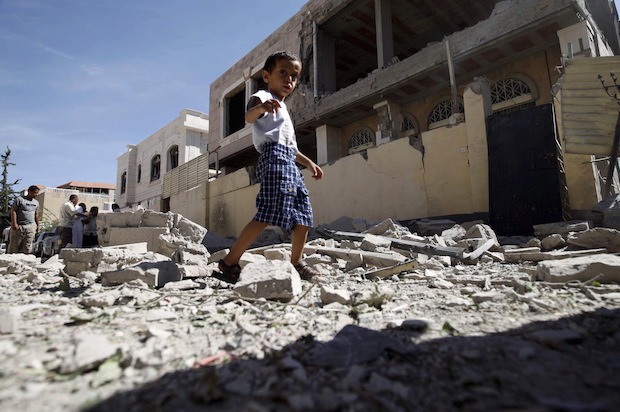 A Yemeni child walks past a house damaged by a Saudi-led air strike in Yemen's capital Sanaa on September 12, 2015 (Reuters/Mohamed al-Sayaghi)