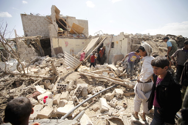Yemenis outside a house that was destroyed by a Saudi-led coalition airstrike in Yemen's capital Sanaa on February 25, 2016 (Reuters/Mohamed al-Sayaghi)