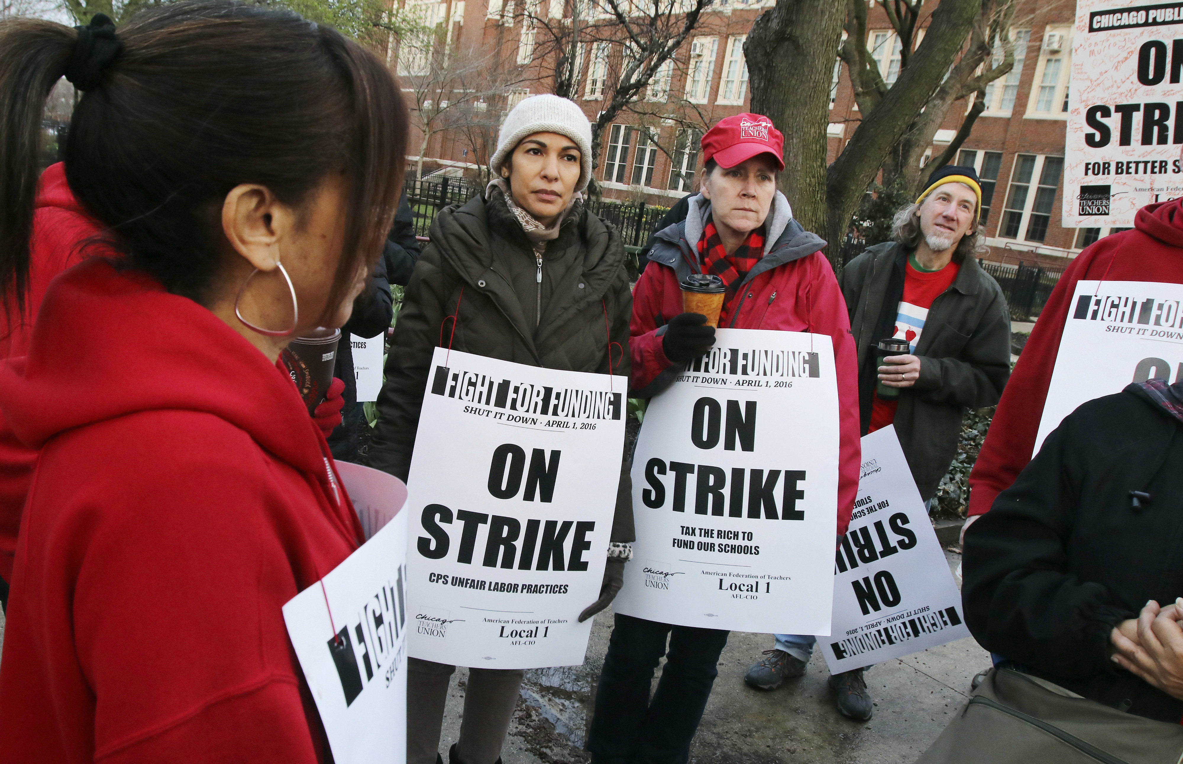 Chicago teachers and supporters gather to talk outside Amundsen High School in Chicago, Friday, April 1, 2016, during a one-day strike they say is aimed at getting lawmakers to adequately fund education and other programs in the nation's third-largest district. (Tim Boyle/Chicago Sun-Times via AP)  MANDATORY CREDIT, MAGS OUT, NO SALES; CHICAGO TRIBUNE OUT (AP)