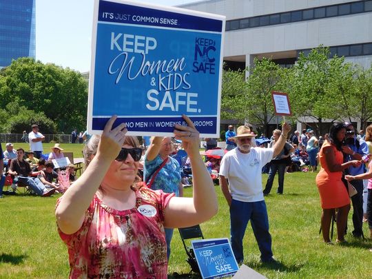A supporter of HB2 holds a sign at a demonstration Monday in Raleigh. (Mark Barrett/mbarrett@citizen-times.com)