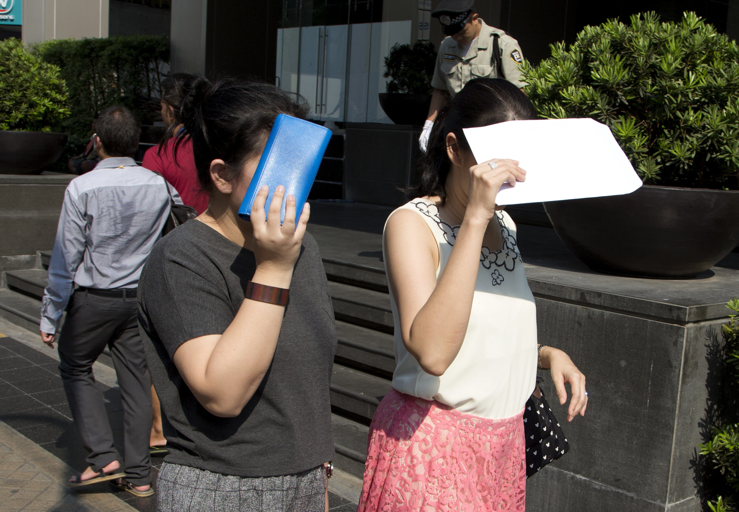 Pedestrians protect themselves from the sun while walking in central Bangkok, Thailand, Wednesday, April 27, 2016. (AP Photo/Mark Baker)