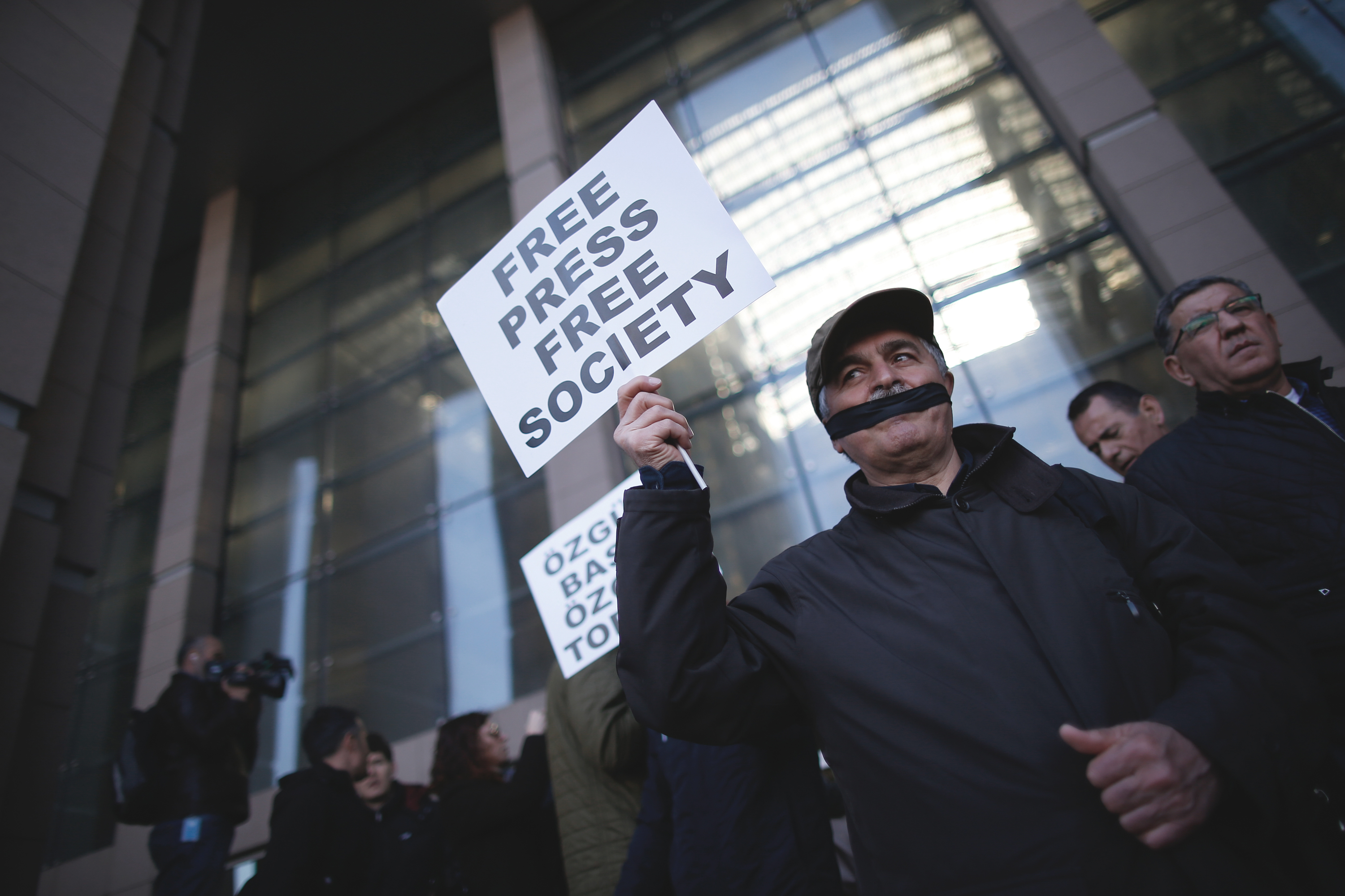 FILE- In this April 1, 2016 file photo, Turkish journalists cover their mouths with black ribbons before the trial of Can Dundar, the editor-in-chief of opposition newspaper Cumhuriyet and Erdem Gul, the paper's Ankara representative, outside the courthouse in Istanbul. Turkeys independent media landscape is rapidly shrinking as a result of government-sanctioned takeovers and forced closure. (AP Photo/Emrah Gurel) (AP)