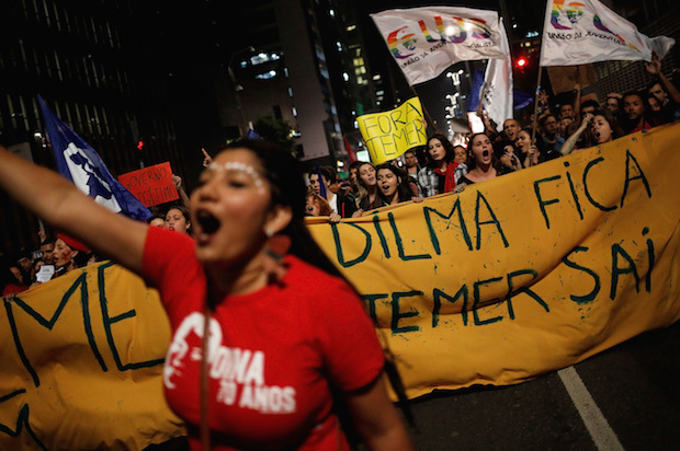 Women shout slogans during a protest against Brazil's interim President Michel Temer and in support of suspended President Dilma Rousseff in Sao Paulo, Brazil, on May 17, 2016. The banner reads "Dilma stays, Temer out" (Reuters/Nacho Doce)