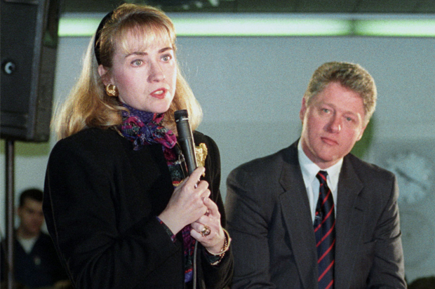 Bill Clinton listens as Hillary Clinton addresses a group at Maine South High School in the Chicago suburb of Park Ridge, March 11, 1992. (Reuters/Sue Ogrocki)