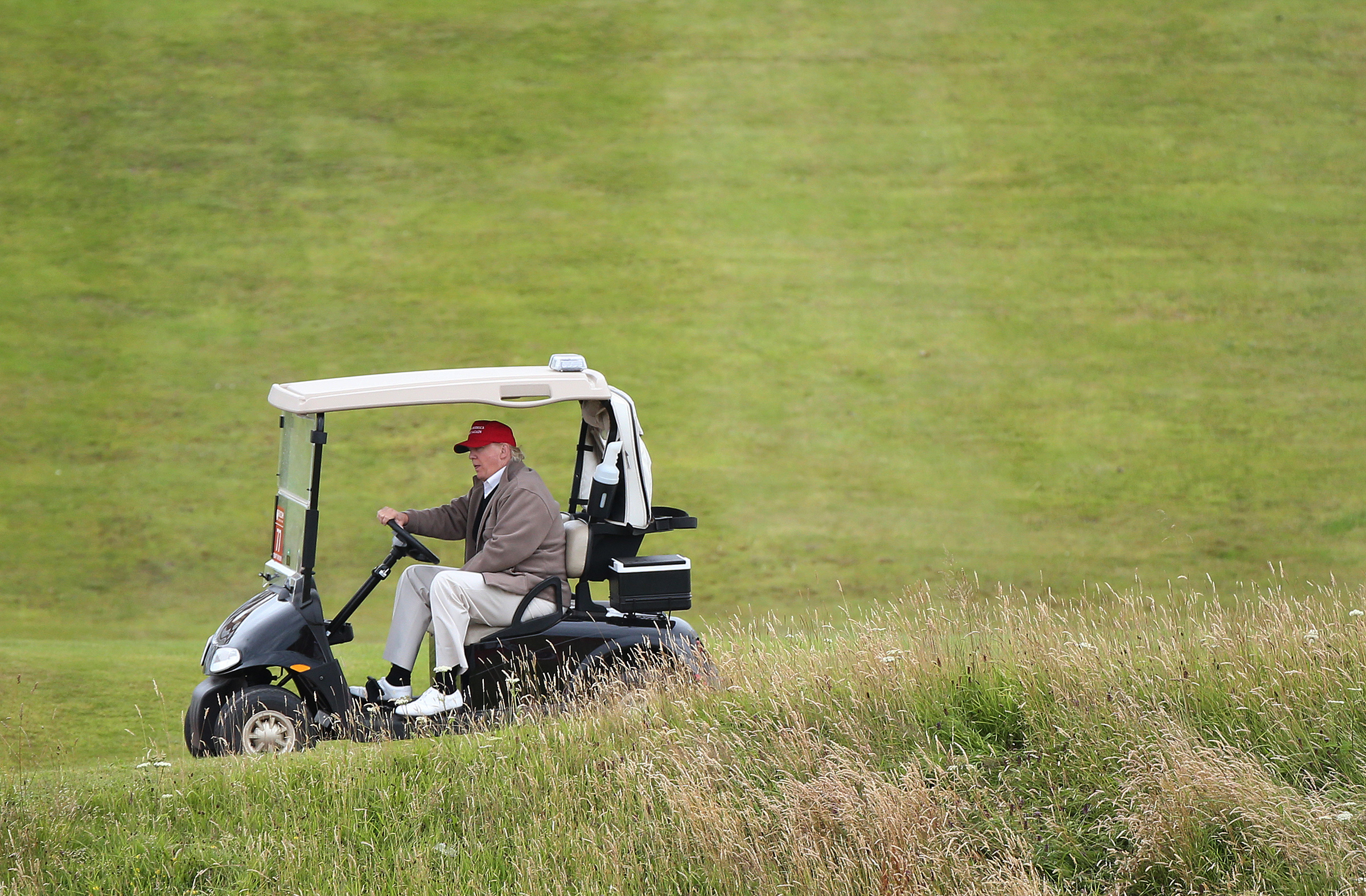 FILE - In this July 31, 2015 file photo, Republican presidential candidate Donald Trump drives his golf buggy during the second day of the Women's British Open golf championship on the Turnberry golf course in Turnberry, Scotland. (AP)