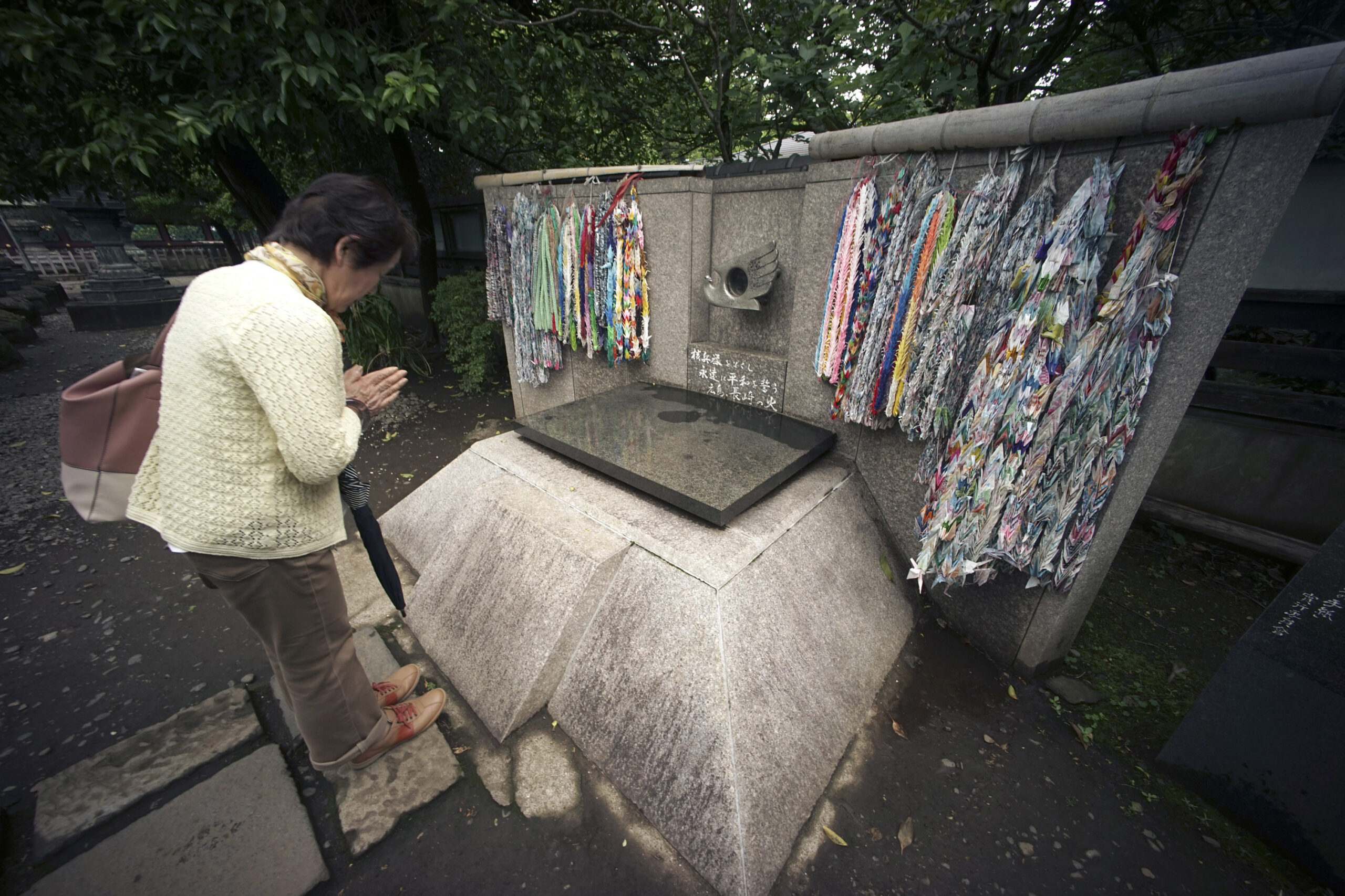 Mieko Mori prays in front of the Flame of Hiroshima and Nagasaki, a memorial monument for A-bomb victims where the flames collected from the ruins in the two cities since dropping of atomic bombs in 1945 have been kept burning at Ueno Park in Tokyo, Wednesday, May 11, 2016. (AP Photo/Eugene Hoshiko) (AP)