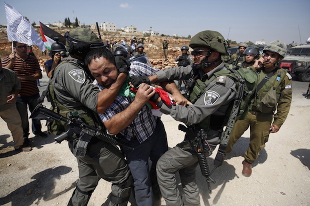 Israeli forces detain a Palestinian protester during a demonstration against illegal Israeli settlements in the occupied West Bank village of Nabi Saleh, near Ramallah on September 4, 2015 (Reuters/Mohamad Torokman)