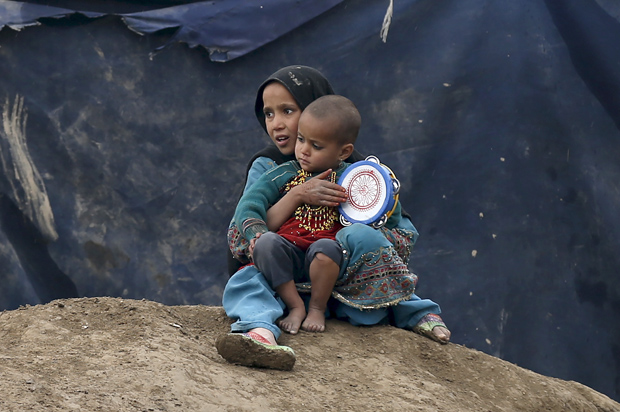 Internally displaced Afghan children sit outside their shelter in Kabul, Afghanistan March 9, 2016. (Reuters/Mohammad Ismail)